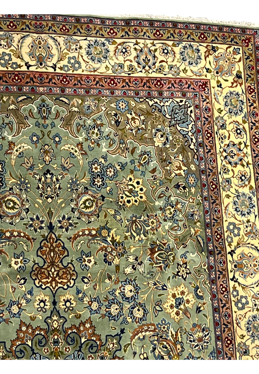 Upper corner of 9'4 x 14'5 Persian Tabriz rug showing light sage-green field, ivory floral border, and intricate vine motifs