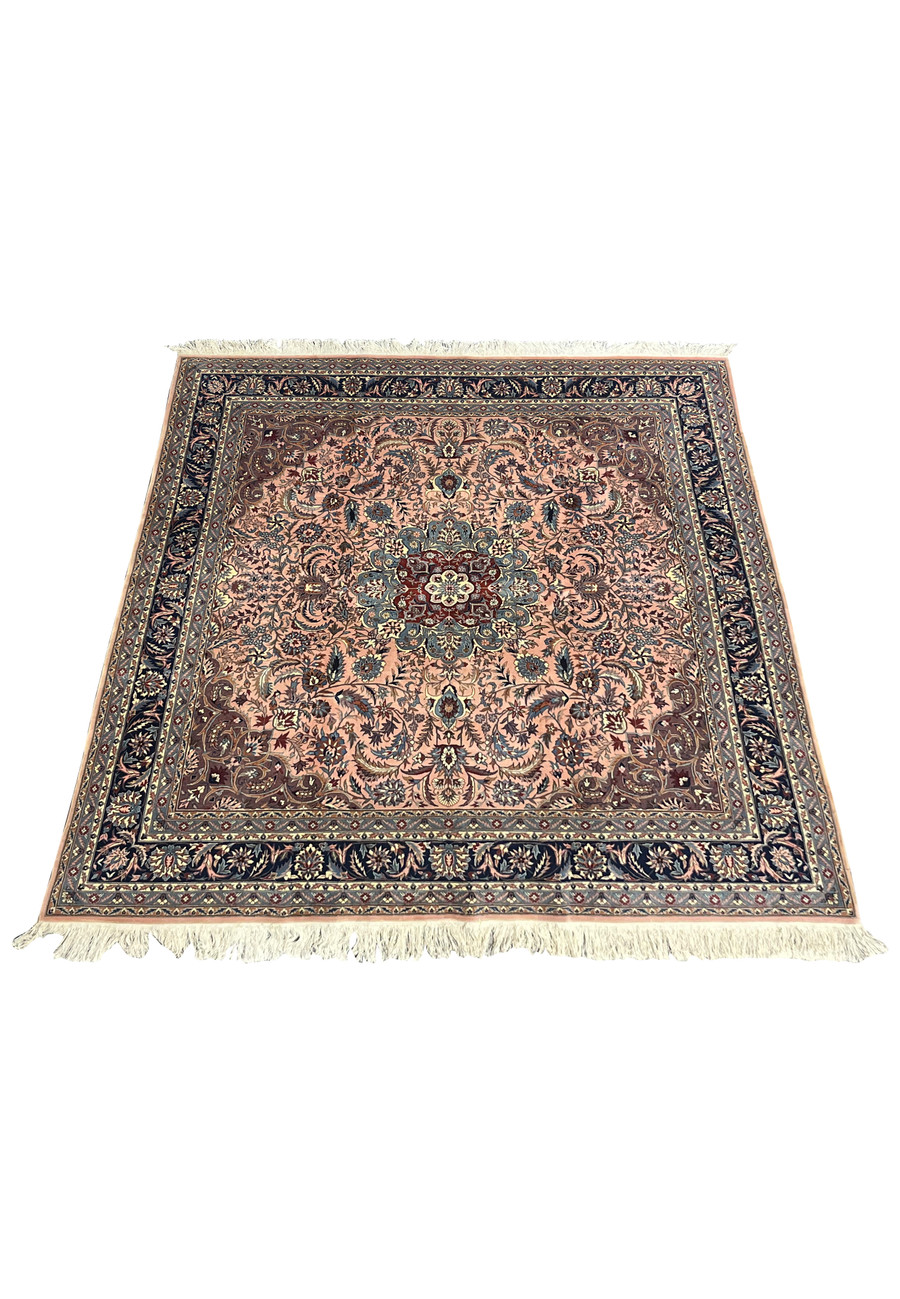 Laid-down view of Persian Tabriz square rug showing salmon background, navy border, and balanced floral motifs