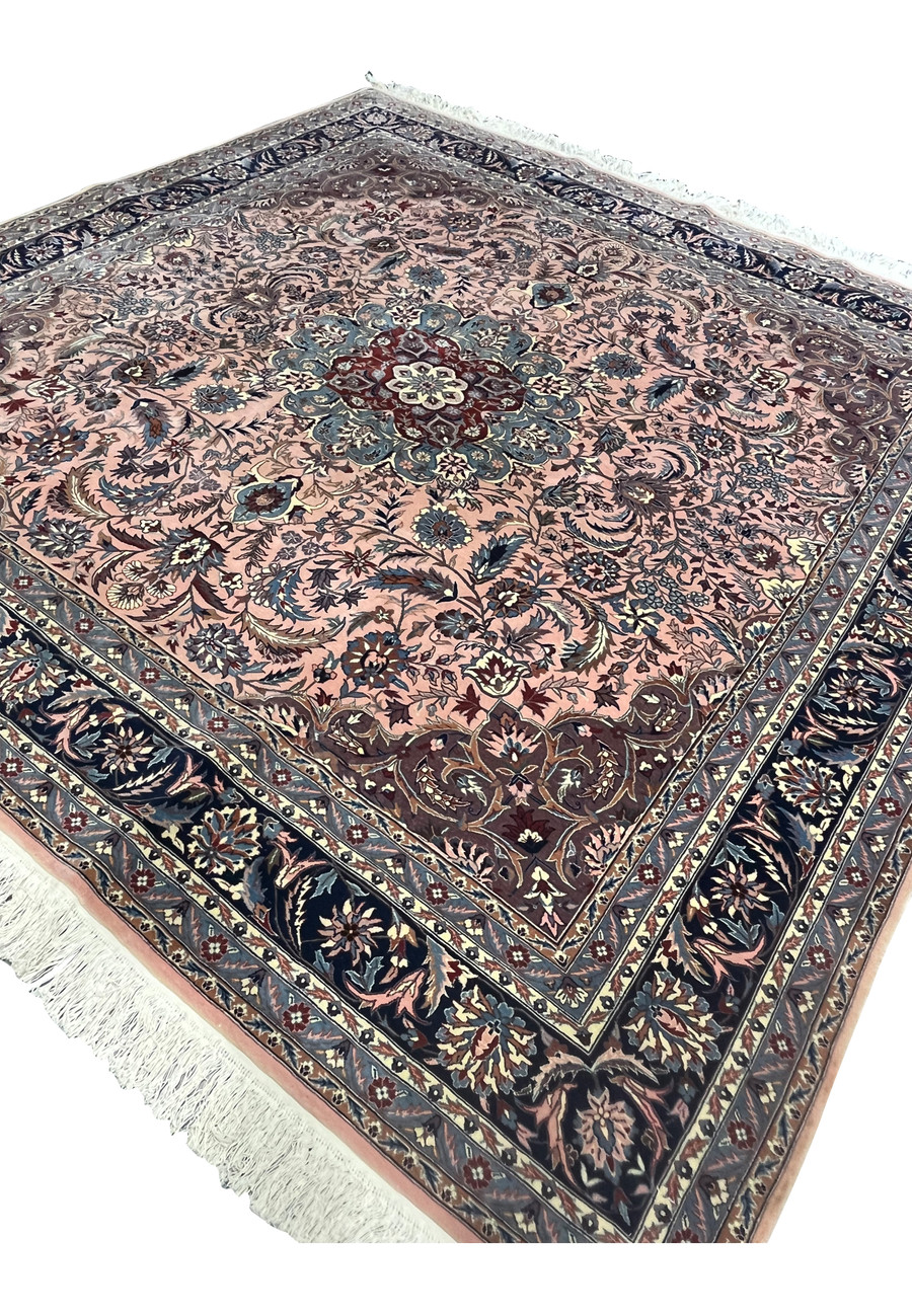 Angled view of Persian Tabriz rug showing pile texture and rich salmon and navy color contrast