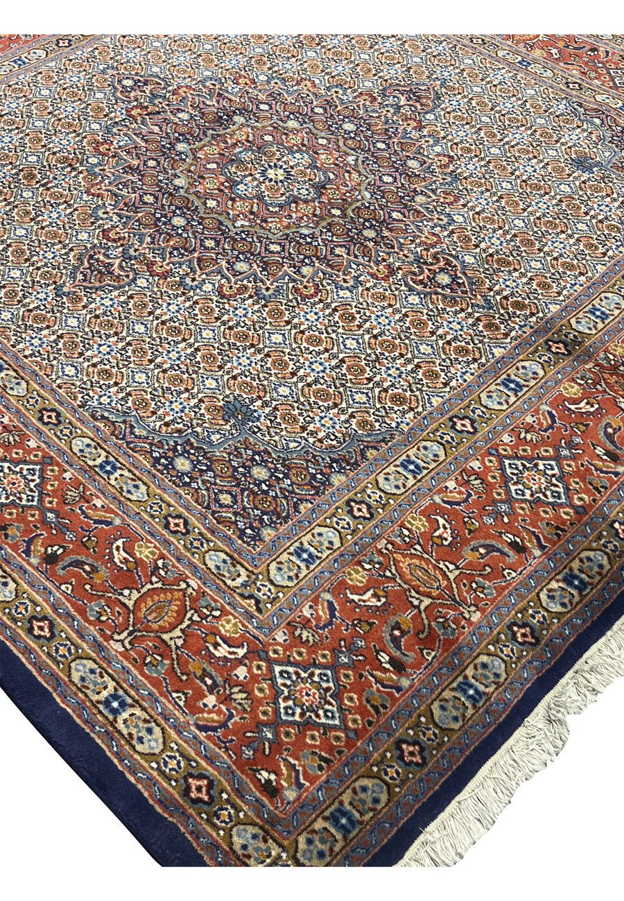 Edge detail highlighting the ivory fringe, rust border, and navy guard stripe framing the ornate Herati field, emphasizing the rug’s handmade precision and durability.