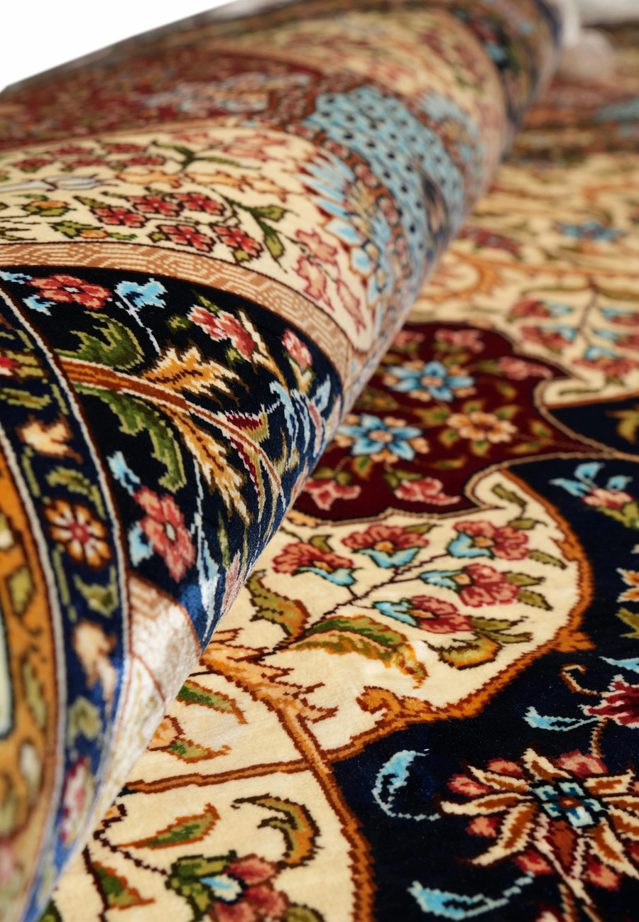 Rolled section illustrating the rug’s texture, pile sheen, and fine silk craftsmanship.