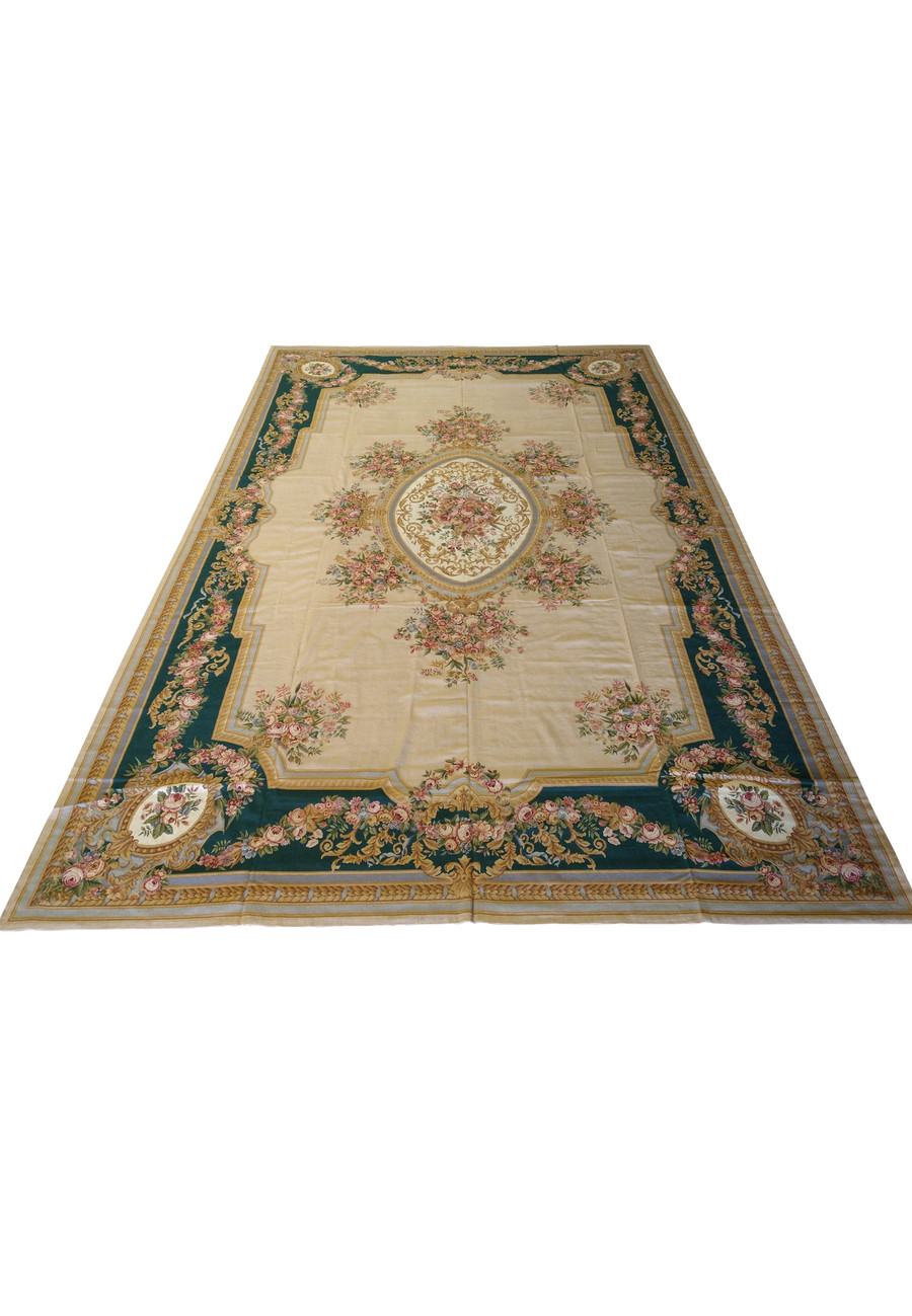 Laid flat view of oversized French Aubusson rug showing full proportions, symmetrical floral layout, beige field, and emerald green framing