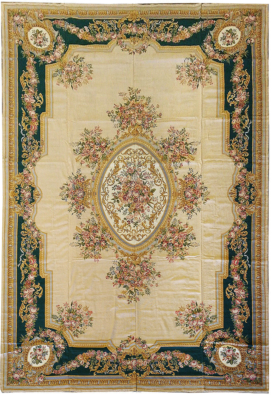 Full view of an 11'4 x 18 French Aubusson rug with beige field, emerald green floral border, oval medallion, and classical rose garland design
