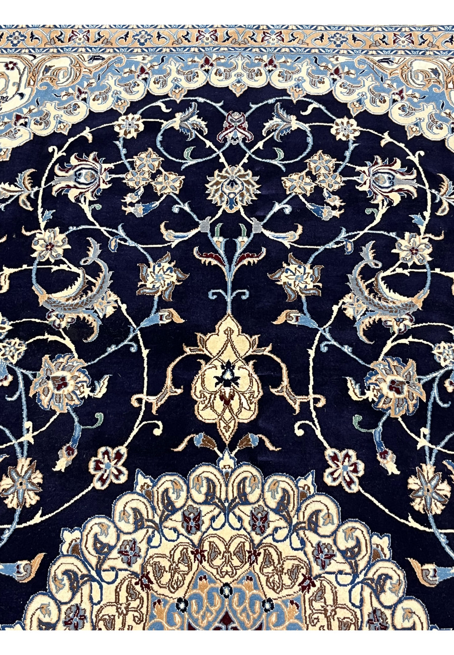 Upper section of a 6'5 x 10 Persian Nain 6 LA rug showing midnight navy field with ivory floral vines, silk highlights, and finely detailed curvilinear motifs