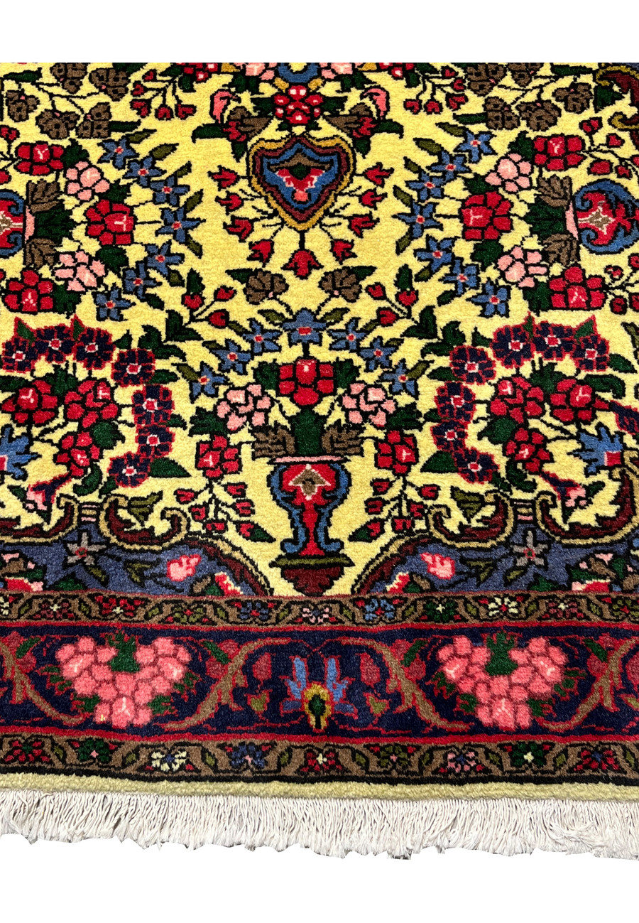 Lower border detail of Persian Bijar rug featuring deep red floral motifs, navy outlines, and traditional Kurdish design elements