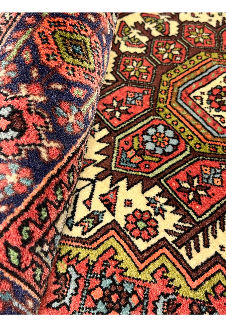Rolled view of Persian Gholtogh rug revealing dense wool pile and flexible tribal weave structure
