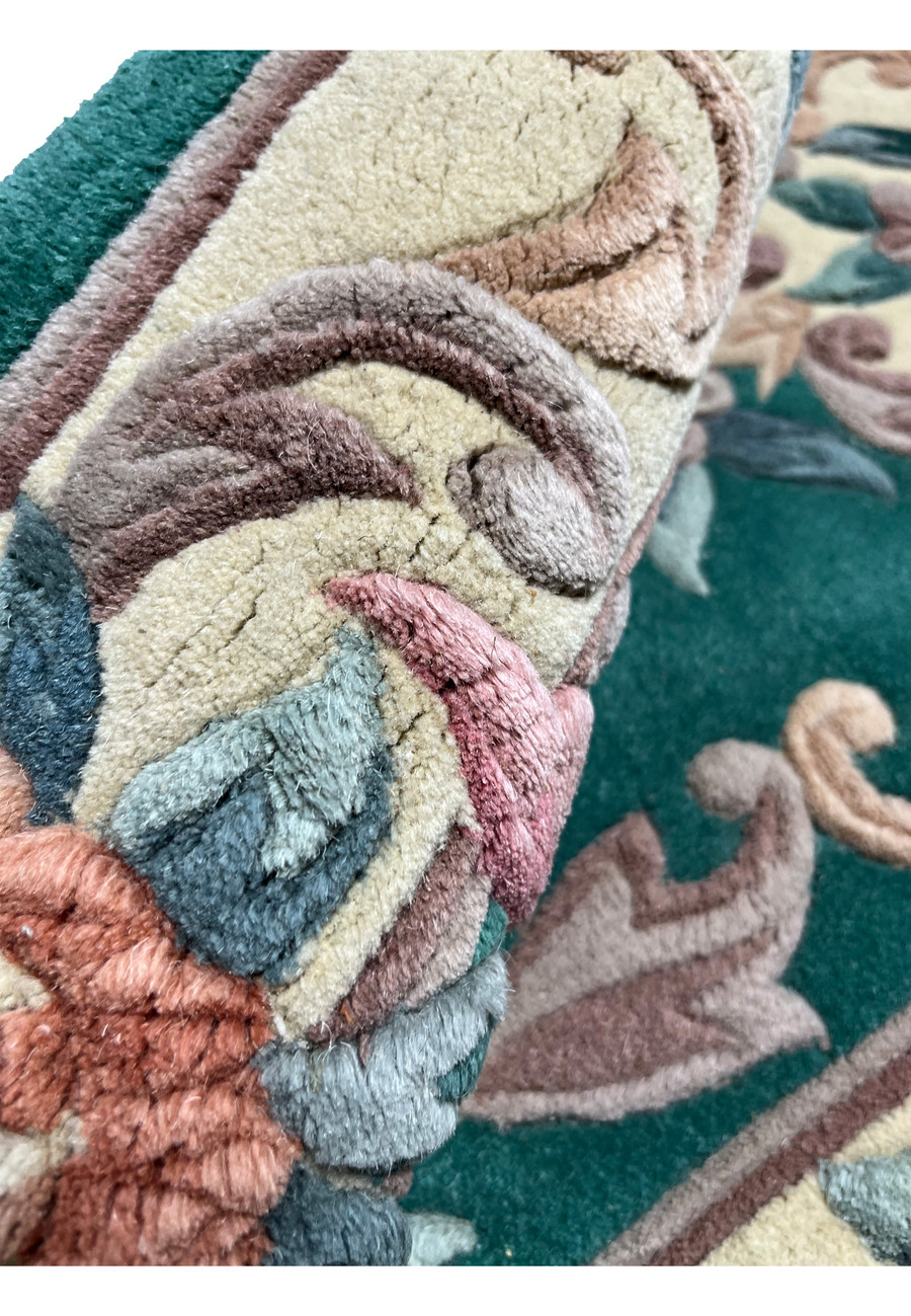 Close-up of floral scrollwork on Aubusson Art Deco rug revealing three-dimensional texture and soft pastel color transitions