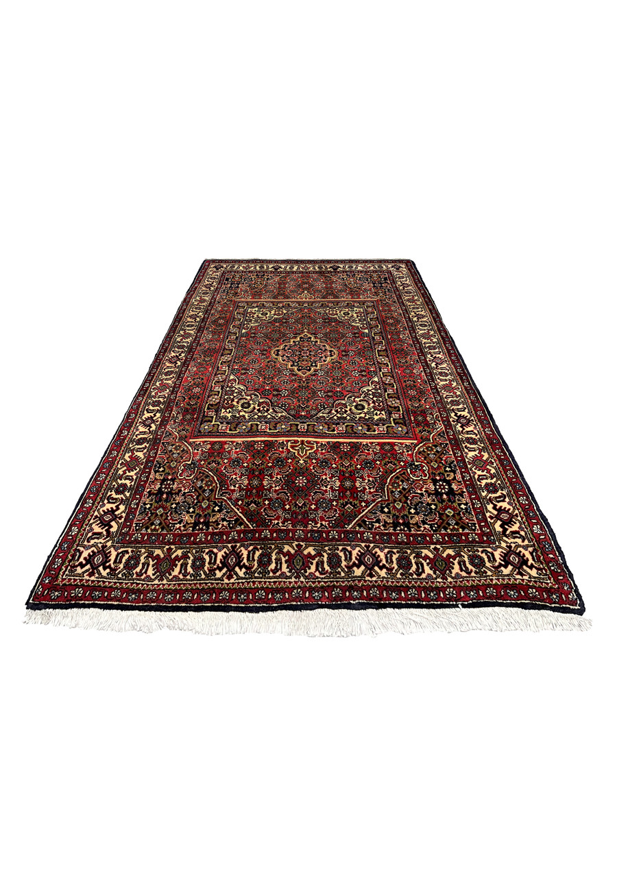 Laid flat view of a Persian Bijar rug showing layered rug-in-rug composition, bold red tones, navy accents, and tightly packed wool texture
