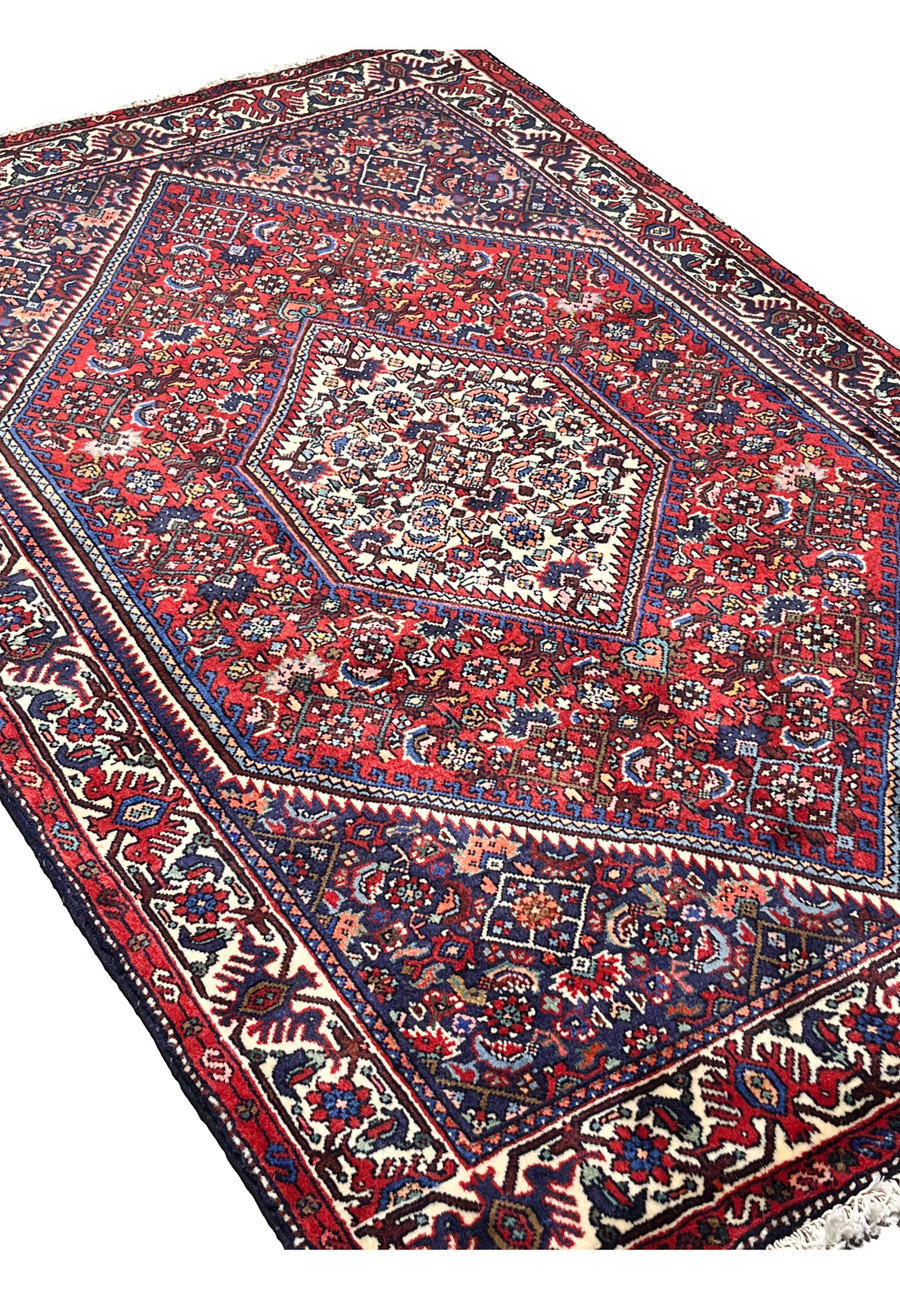 Angled perspective of a Persian Gholtogh rug revealing depth, texture, dense knotting, and balanced tribal composition.