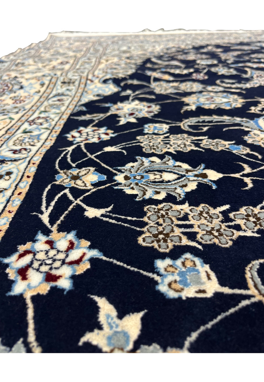 Pattern close-up of a handmade Persian Nain Habibian rug showing fine curvilinear floral motifs and scrolling vines woven with precise 6LA detail