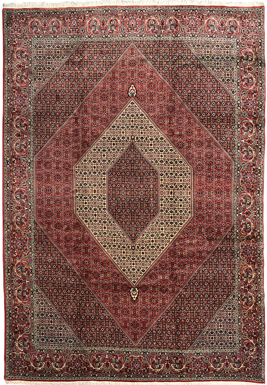 Layered border iron rug with disciplined geometric field in deep brick red