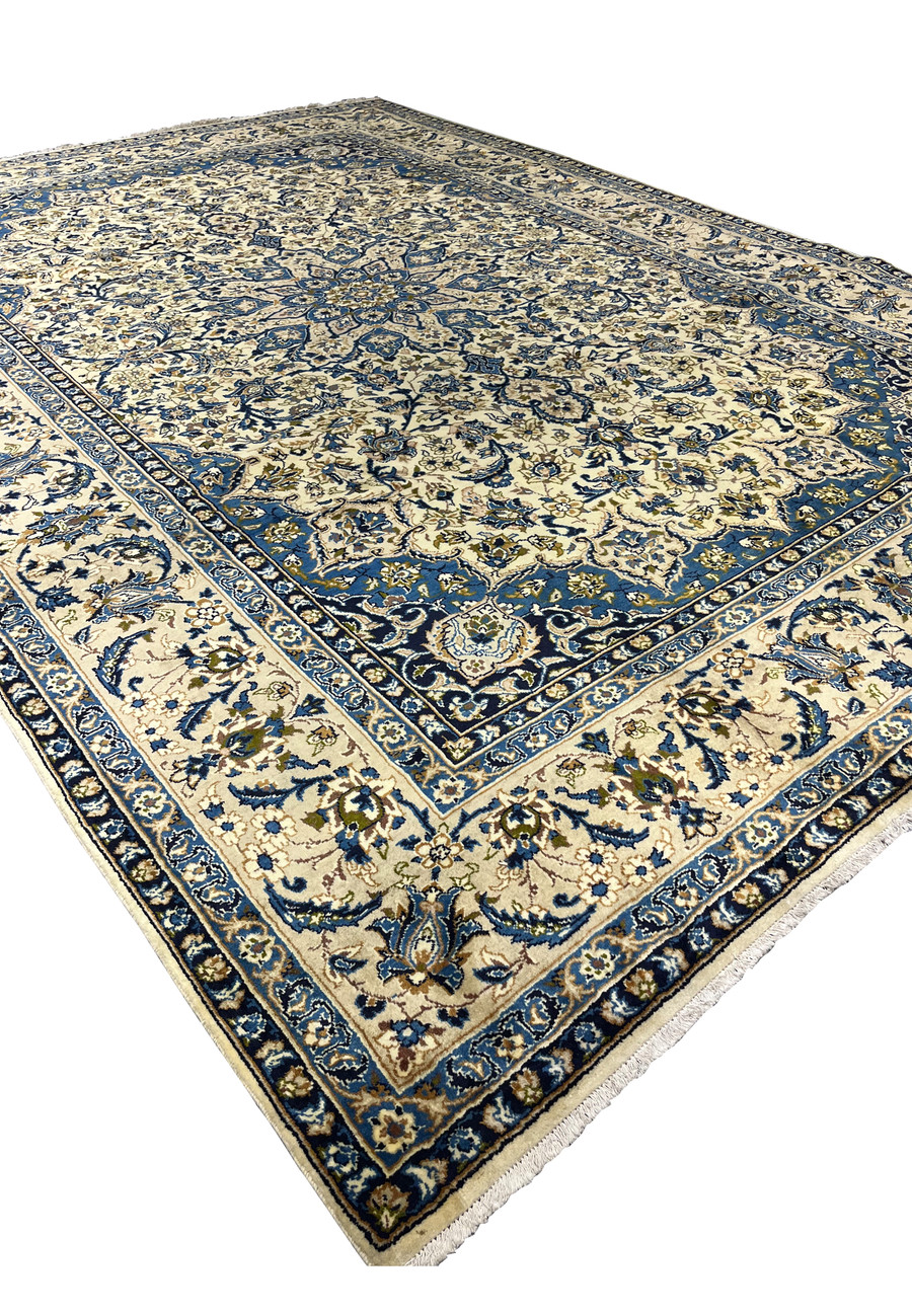 Angled perspective of oversized Persian Kashan rug 10'2 x 14'3 ivory field navy border and classic medallion layout