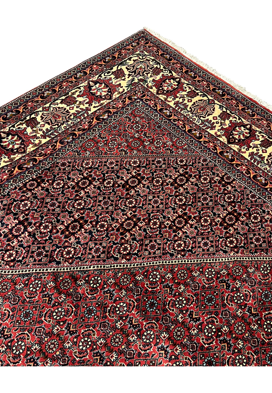 Upper edge corner of 8'2 x 11'4 Persian Bijar Iron Rug displaying ivory main border, floral medallions and tightly woven wool structure