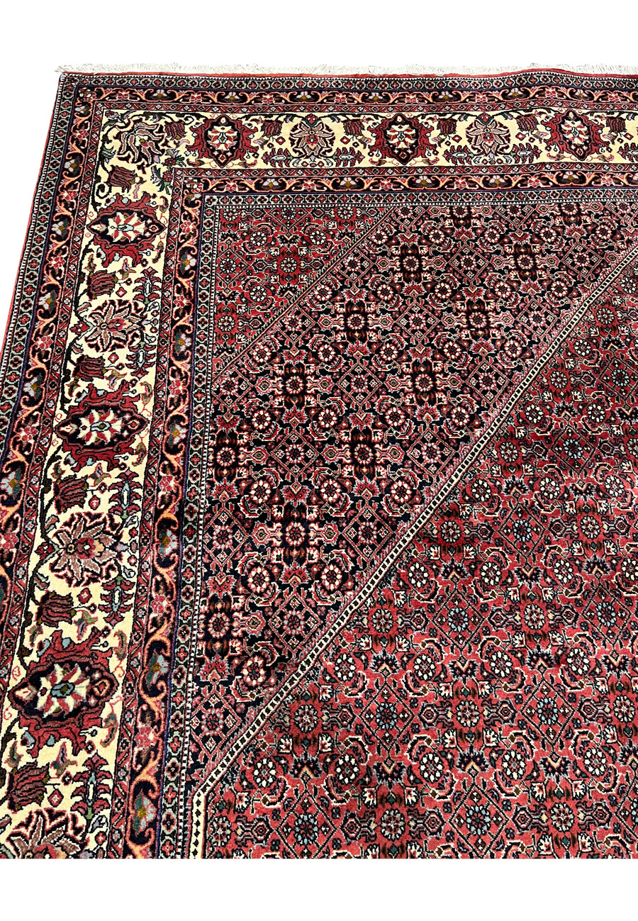 Upper border detail of 8'2 x 11'4 Persian Bijar Iron Rug in deep red and ivory with traditional floral guard borders and strong outlines