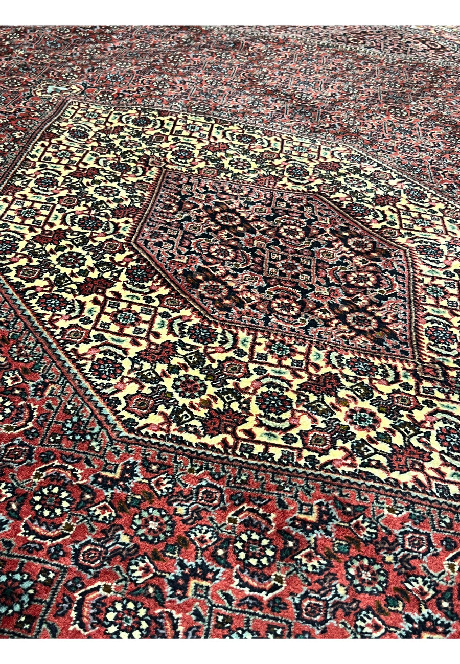 Angled perspective of Persian Bijar Iron Rug 8'2 x 11'4 showing thick compact pile, diamond medallion layout and deep red wool texture