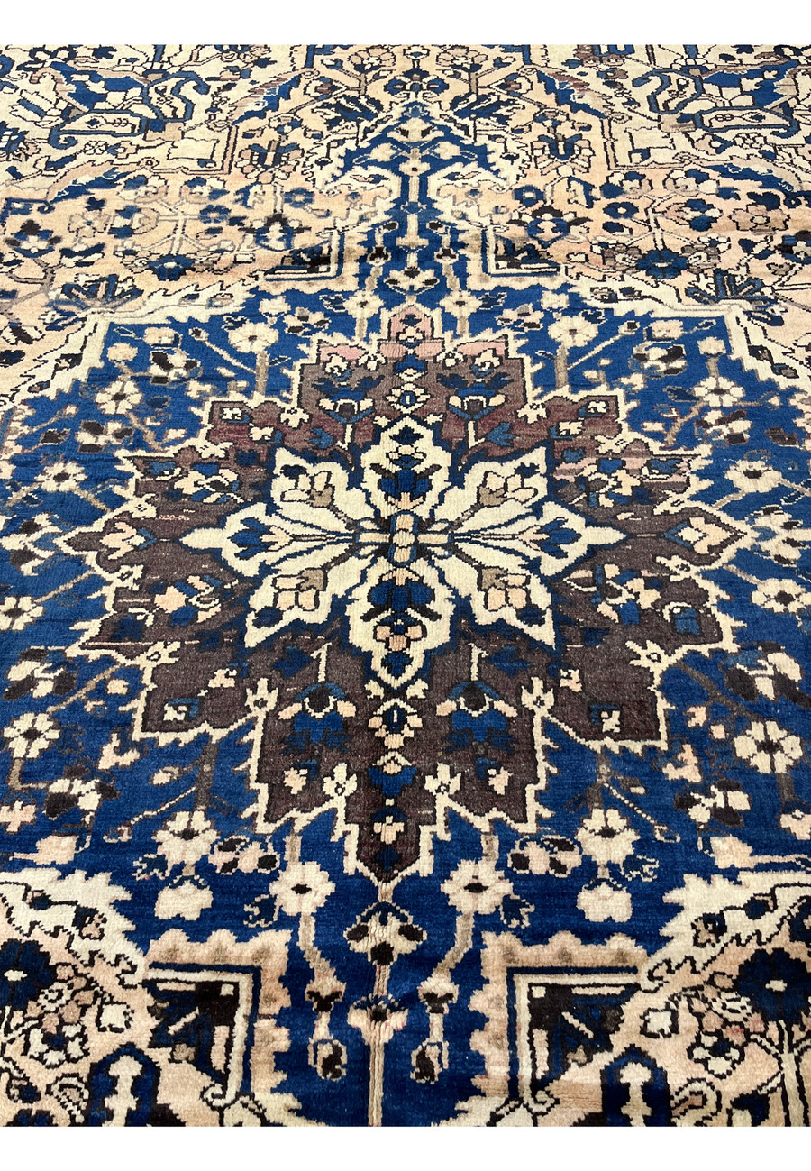 Close up of navy geometric medallion on ivory background vintage Persian Heriz rug with rich wool texture and tribal detailing