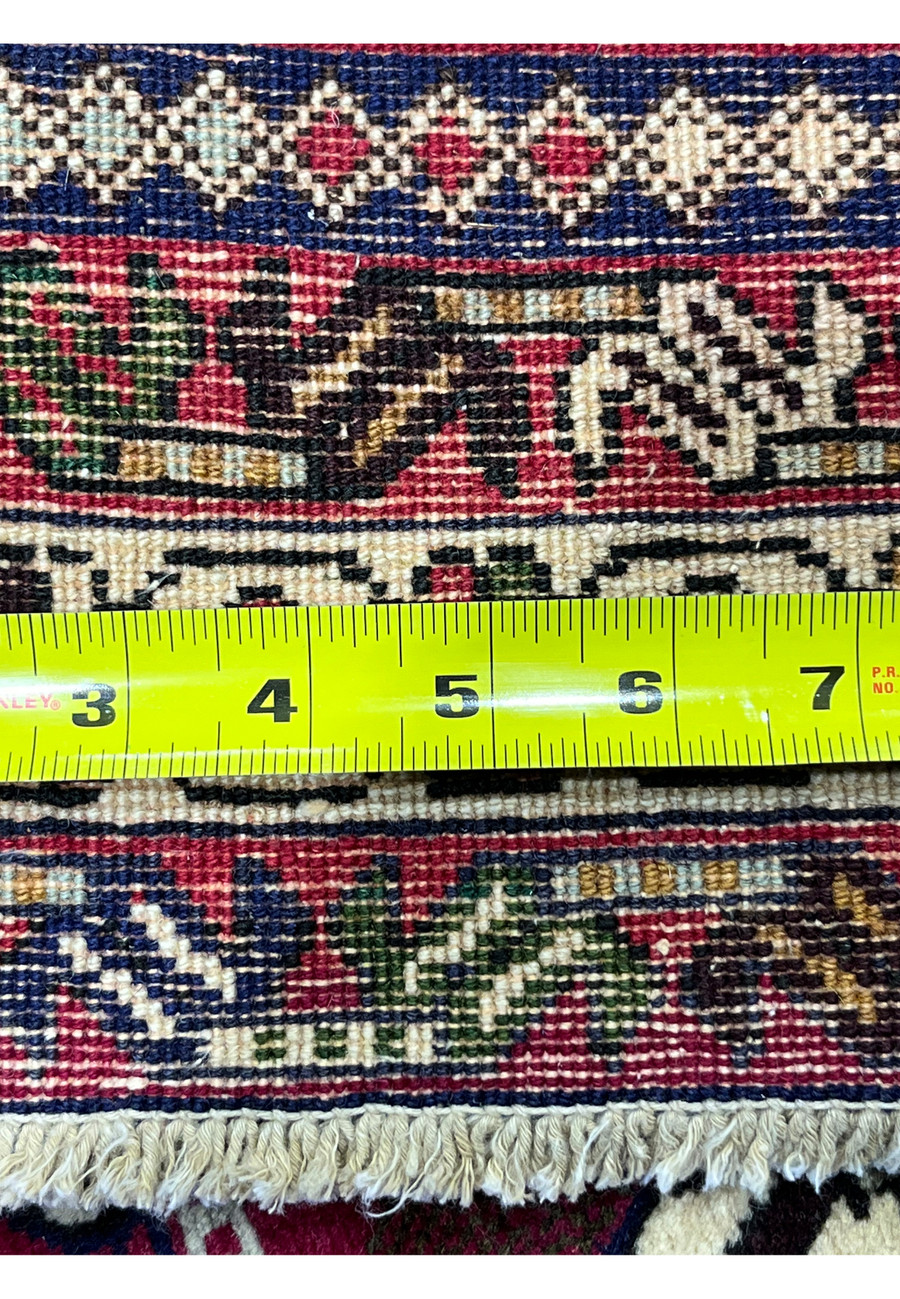 Backside of 5x8 Persian Afshar rug with ruler showing thick pile depth and knot density
