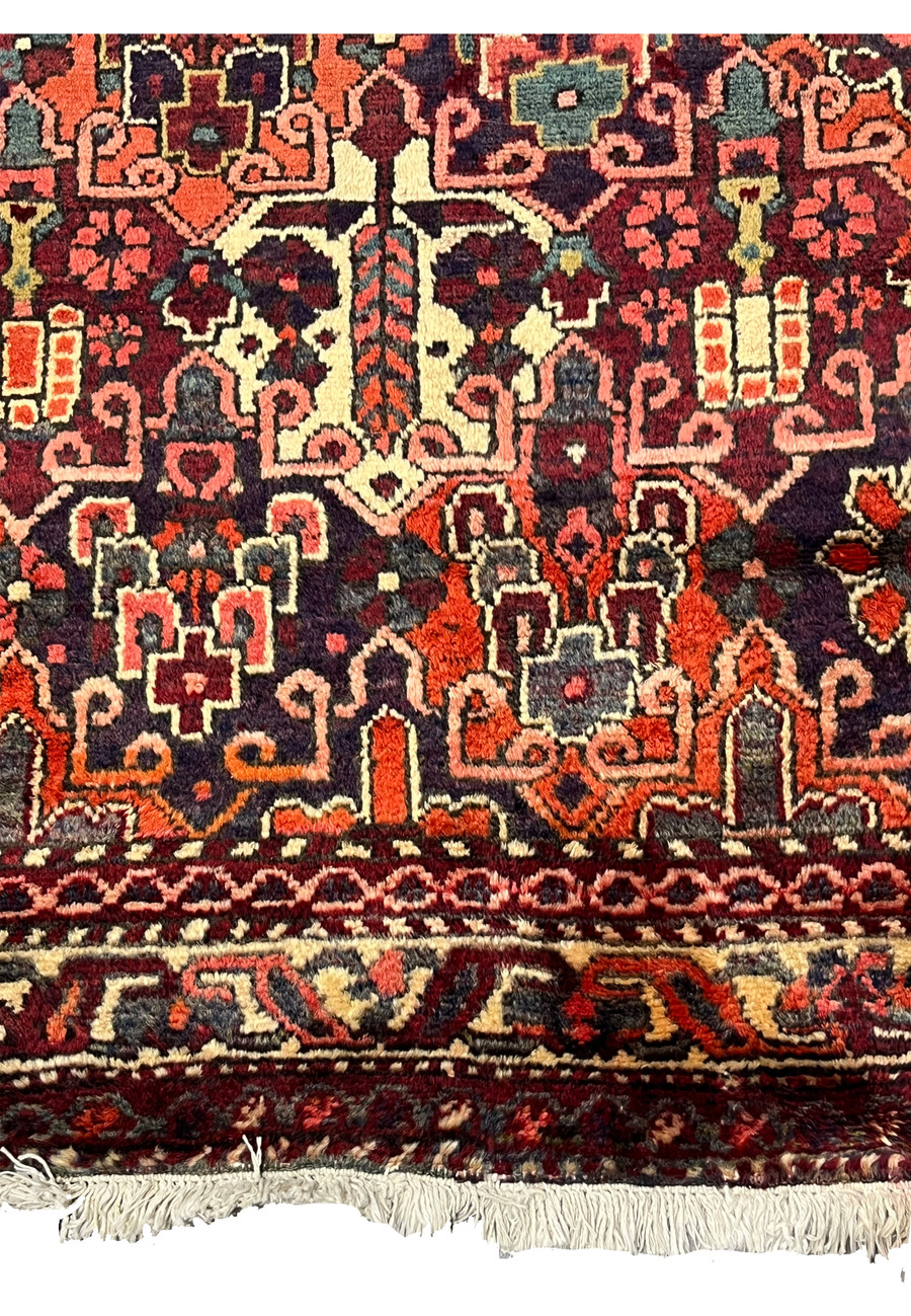 Lower border of antique 3'7x5 Persian Bakhtiari rug showing ivory and navy botanical band
