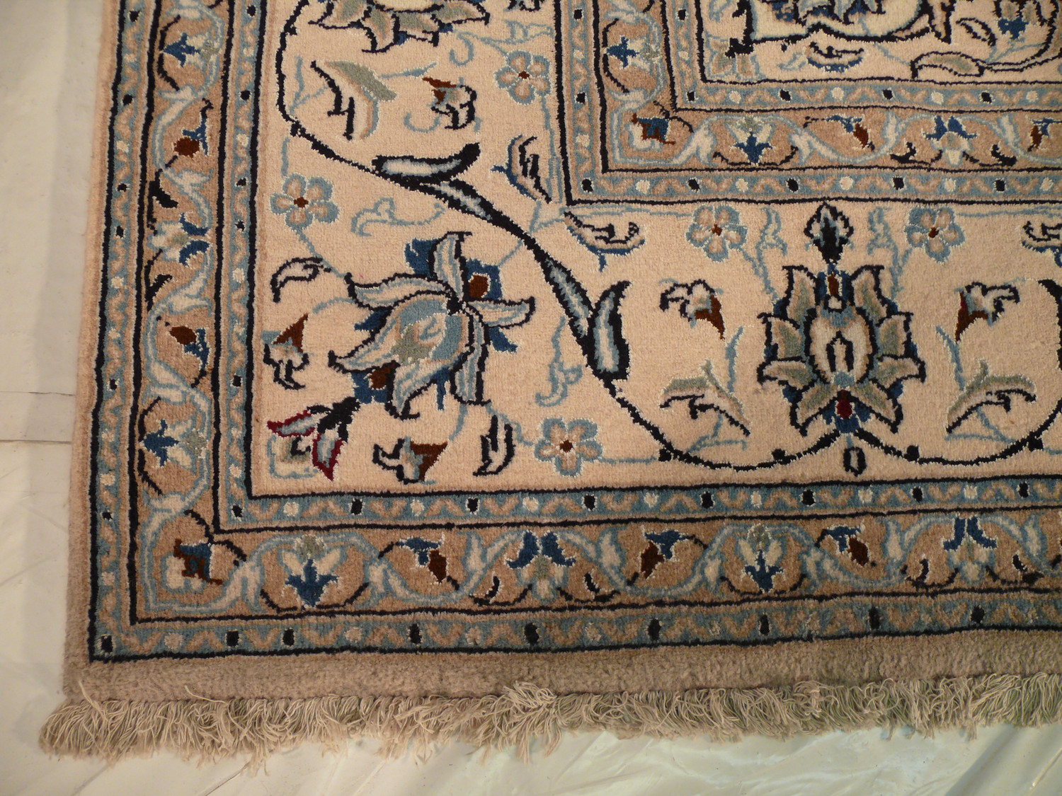 This picture features a stunning Persian Nain wool and silk rug, showcasing its intricate border design. Measuring in at a size that is sure to impress, this rug adds elegance and sophistication to any room in your home. The exceptional quality and craftsmanship of this rug are highlighted in the image, making it a statement piece that is sure to be admired by all who see it.