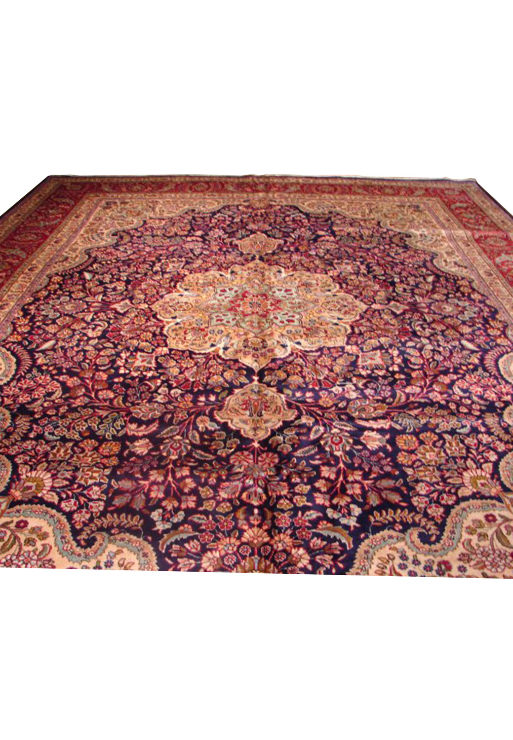 Image showcasing the detailed wide border of a Mashad rug with elaborate red and beige patterns on a navy background
