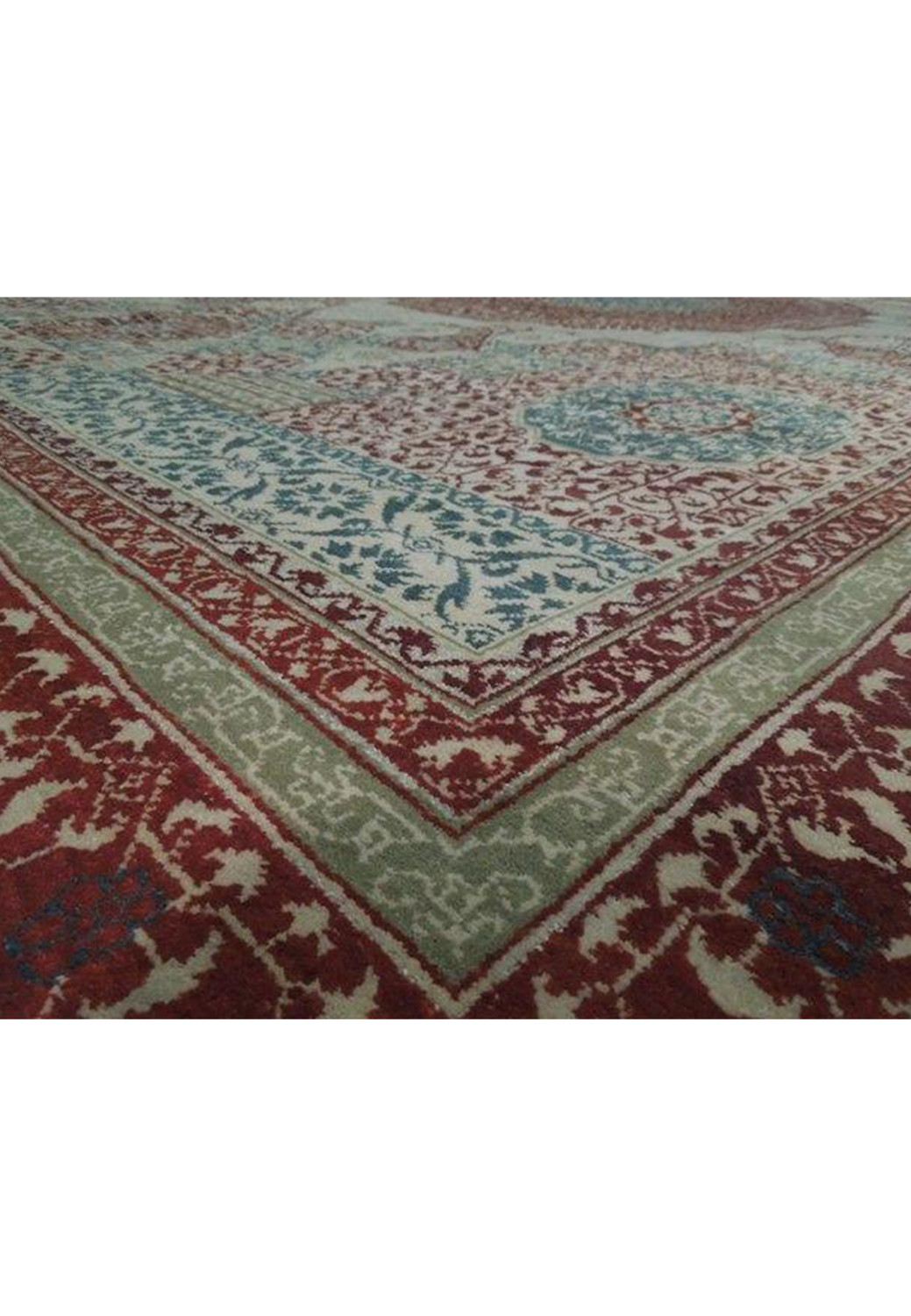 Angled shot of the authentic Agra rug highlighting its elaborate border designs and the interplay of burgundy, cream, and navy hues
