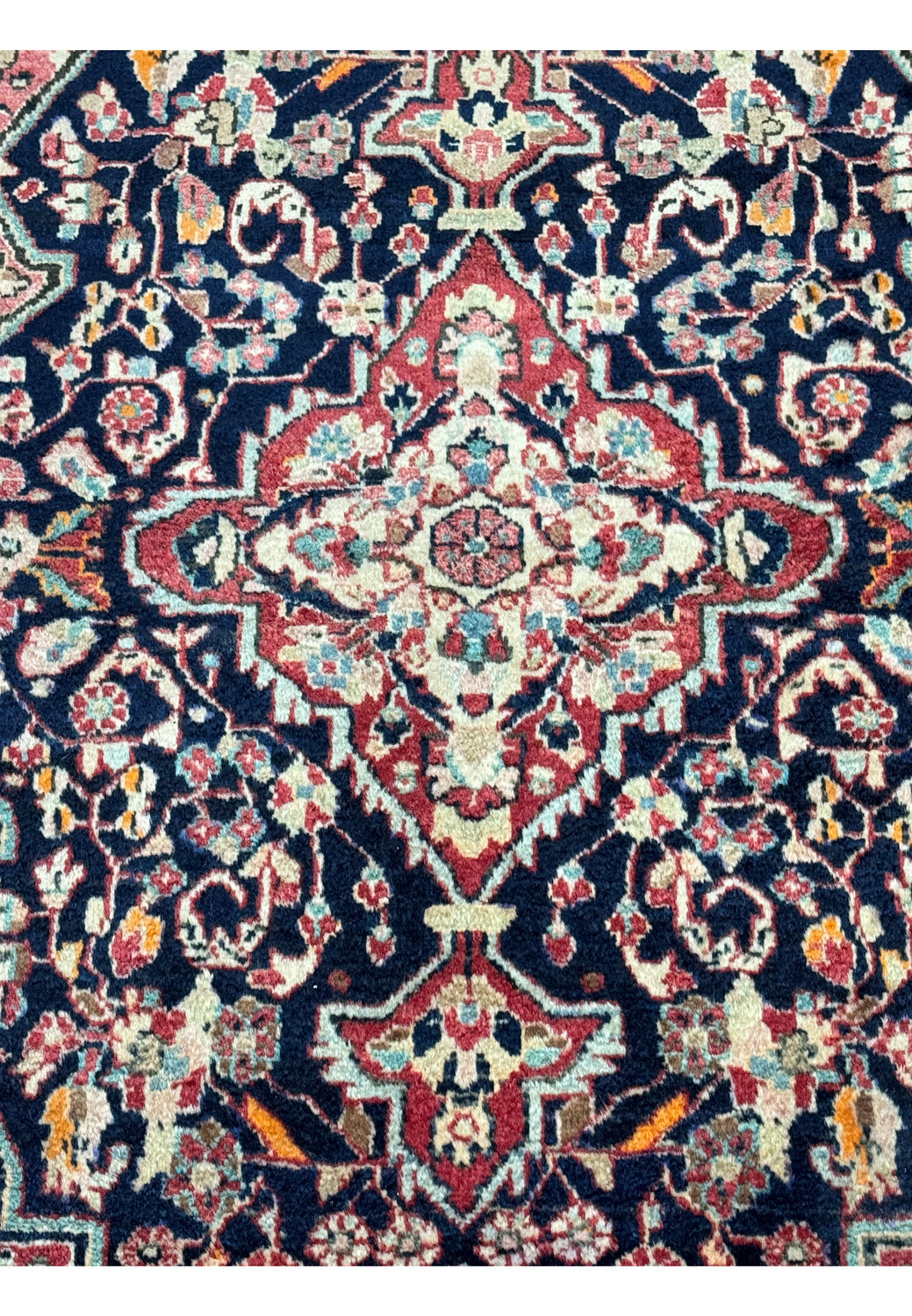 Zoomed-in view focusing on the central medallion of the Persian Sarough Rug, featuring detailed floral motifs in shades of cream, red, and blue.