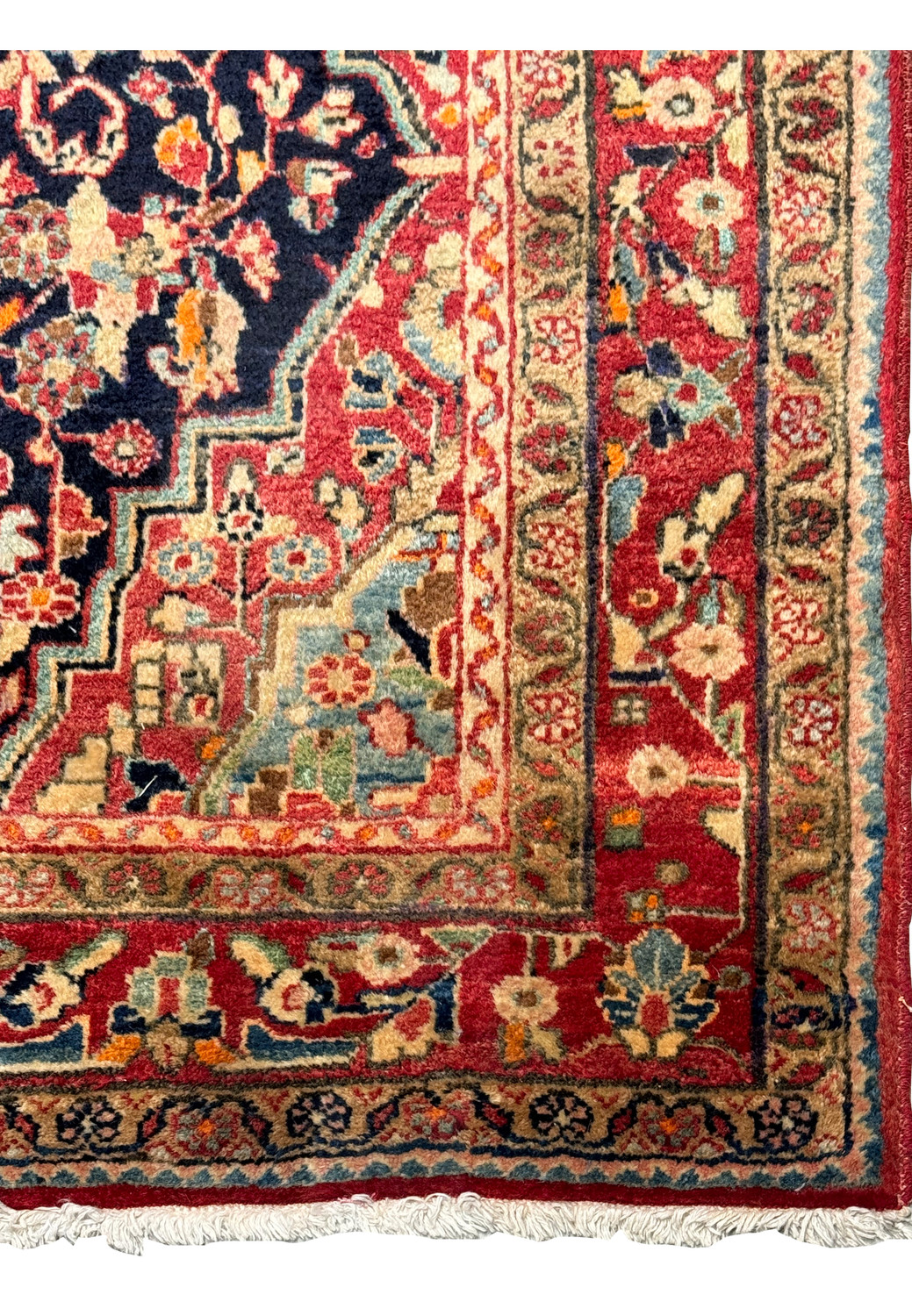 A corner section of the Persian Sarough Rug, displaying the symmetry of the border designs in crimson, sage green, and navy blue.