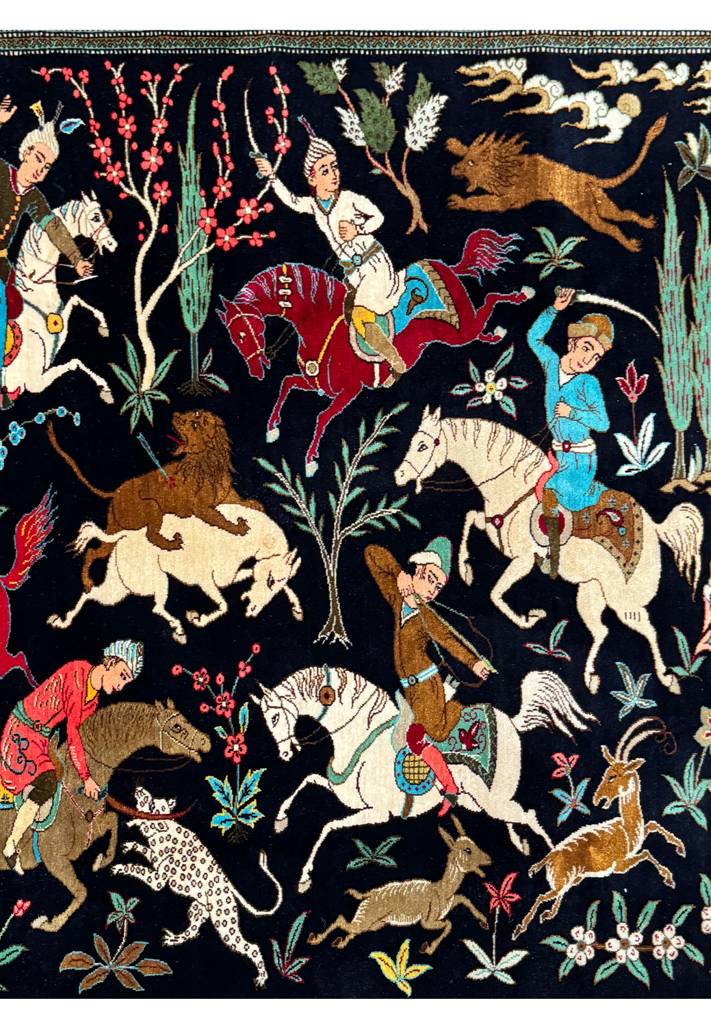 Detailed close-up of a section of Persian Qum Silk Hunting Rug with hunters and animals, emphasizing the vibrant colors and narrative design