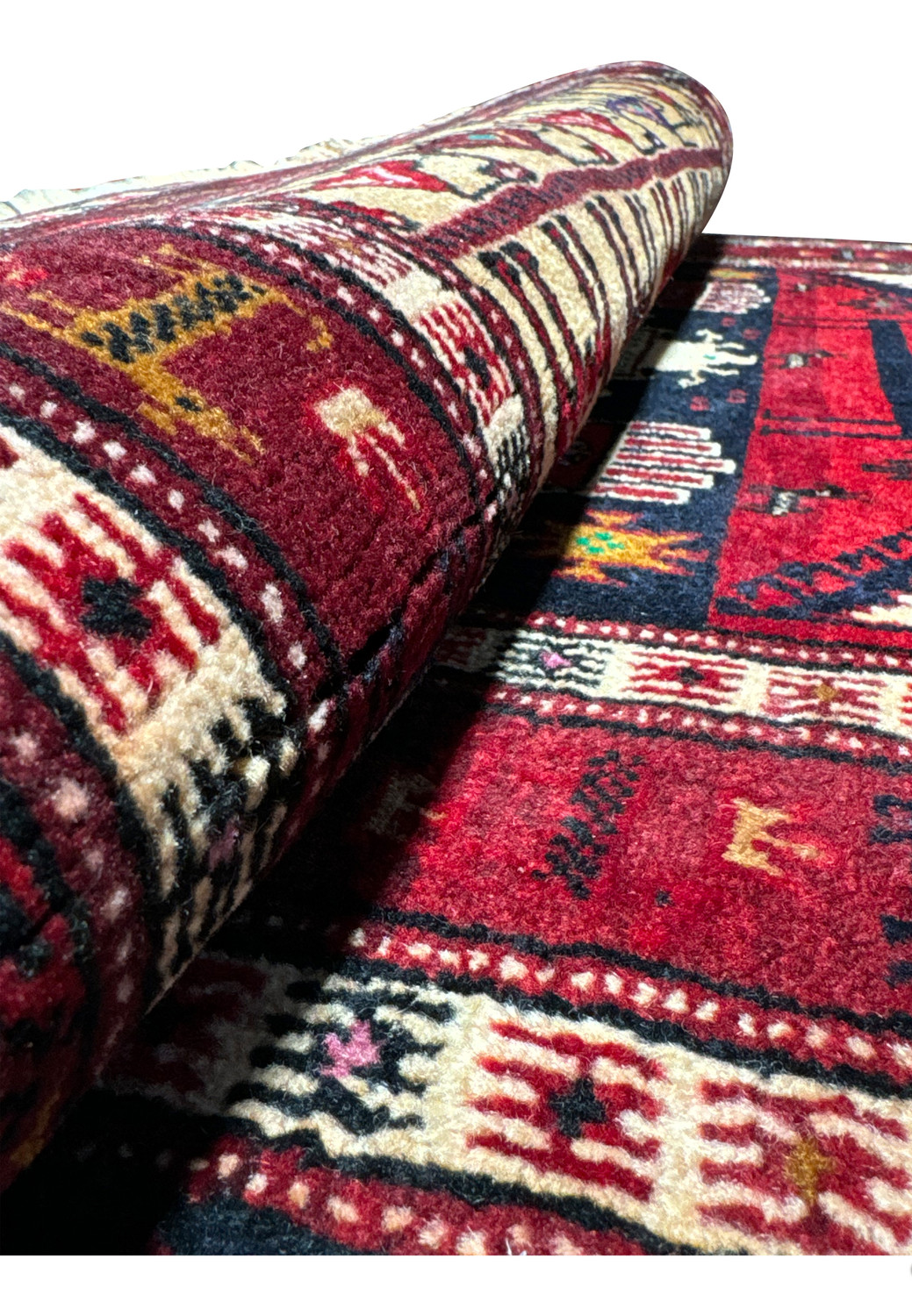 Side view of a rolled Persian Baluch Tribal rug, emphasizing the thickness and intricate weaving patterns