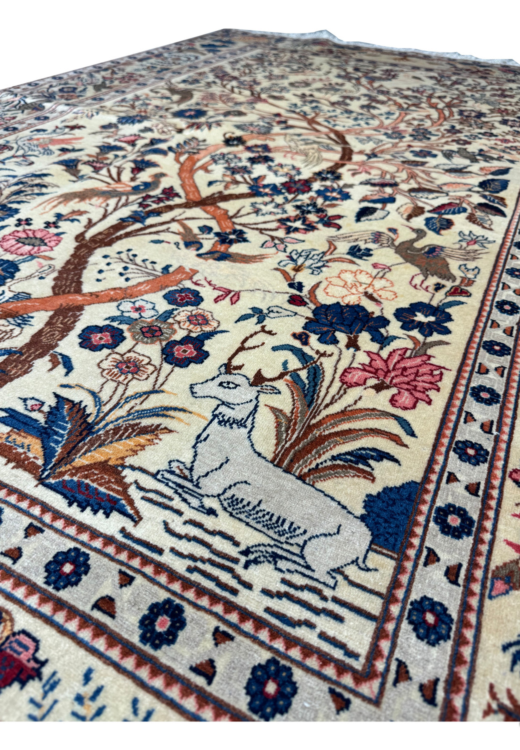 Magnified view of the Tree of Life central motif on an Antique Persian Kashan rug, with detailed depiction of birds in the branches and animals on the ground.