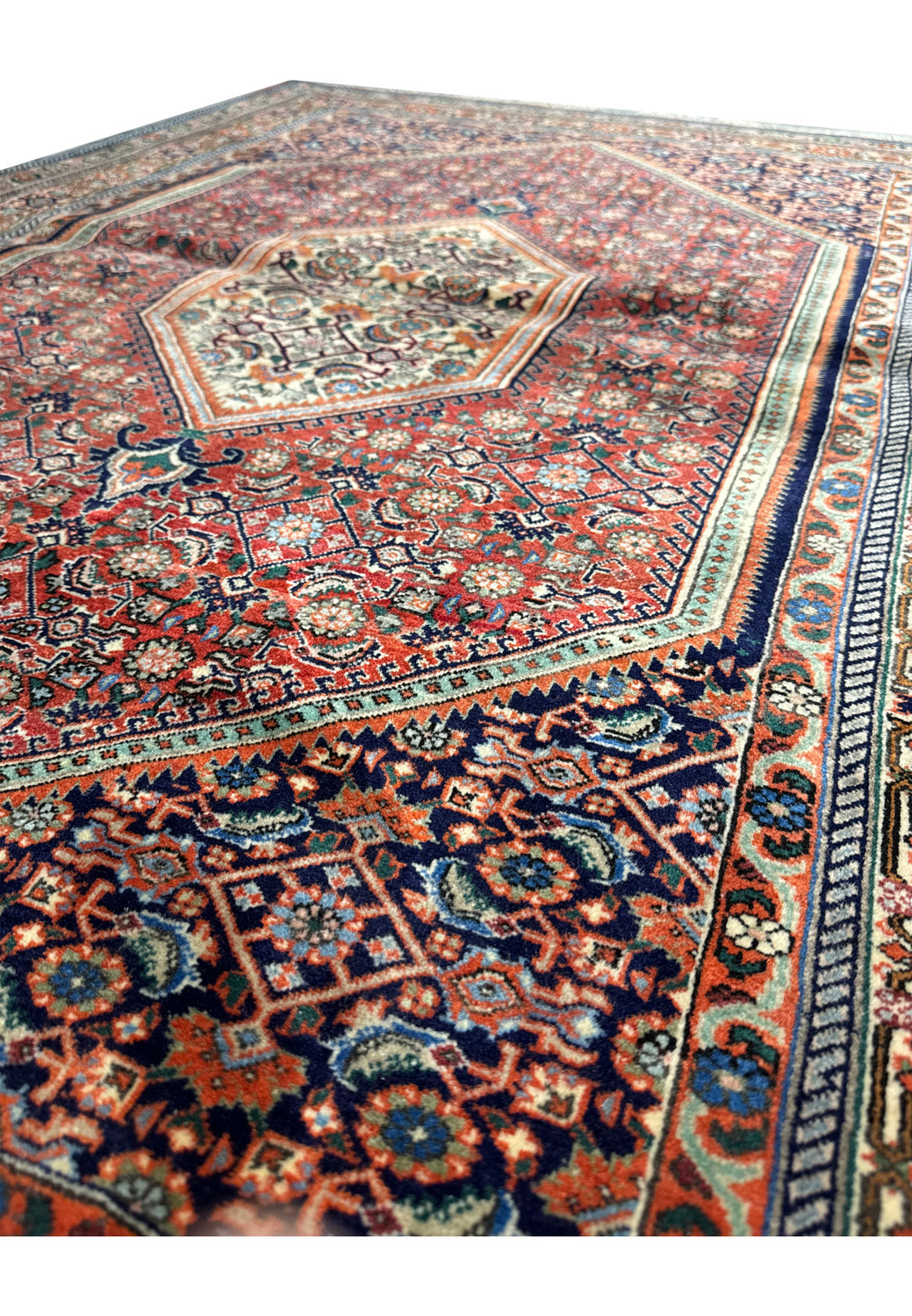 Close-up view of the central part of a Persian Bijar rug, highlighting the elaborate floral motifs and the contrasting colors within the medallion