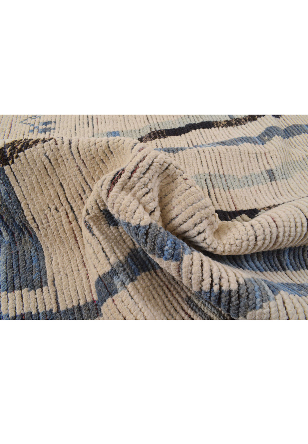 Curved edge of the rug, focusing on the intricate patterns and the soft undulation of the rug's edge.