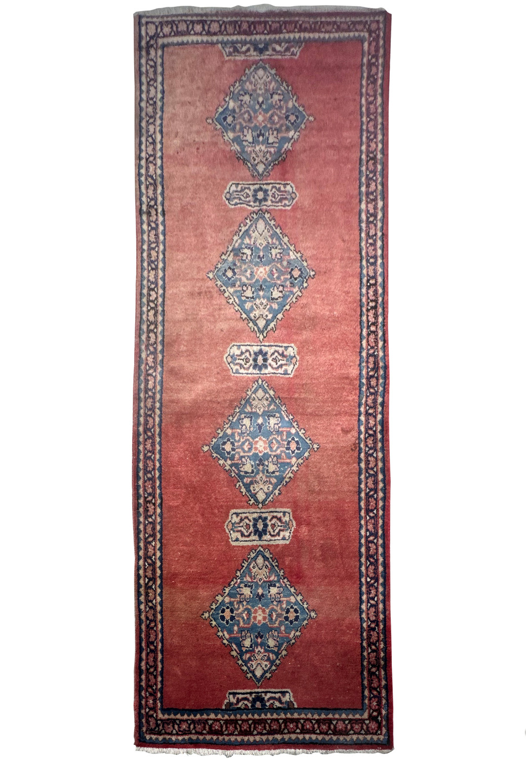 An overhead view of a Persian Hamedan runner rug with a deep red field and blue and cream medallions