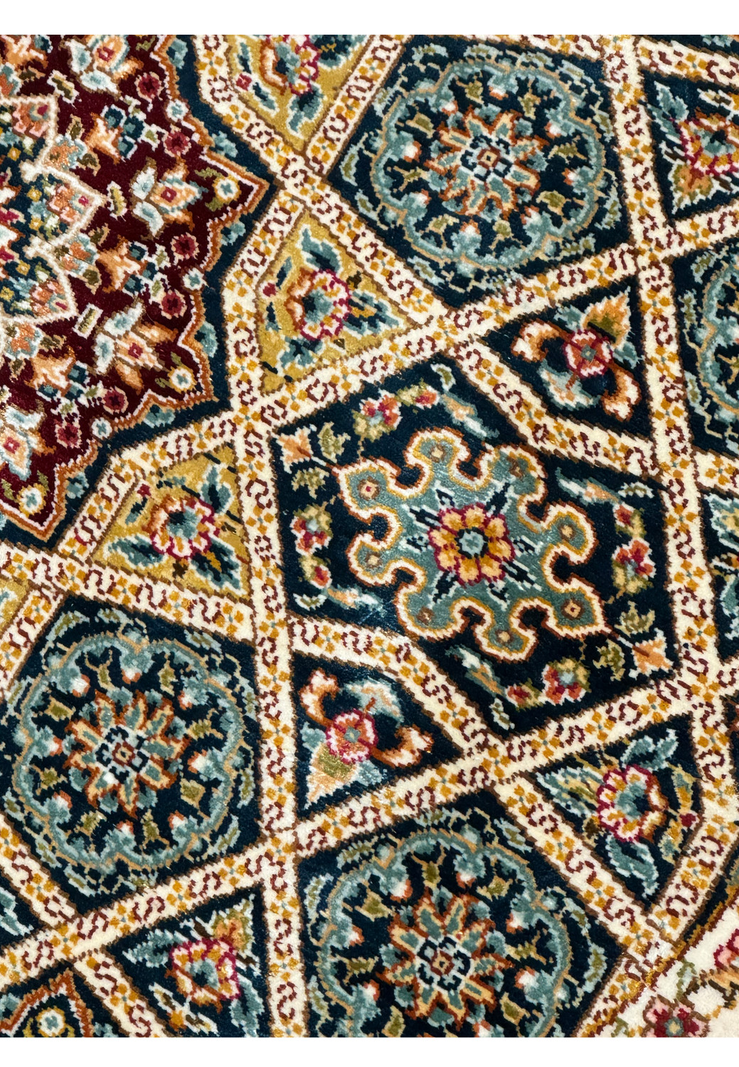 Detailed perspective of the Persian Qum silk rug patterns, with focus on the vibrant medallions and ornate florals.