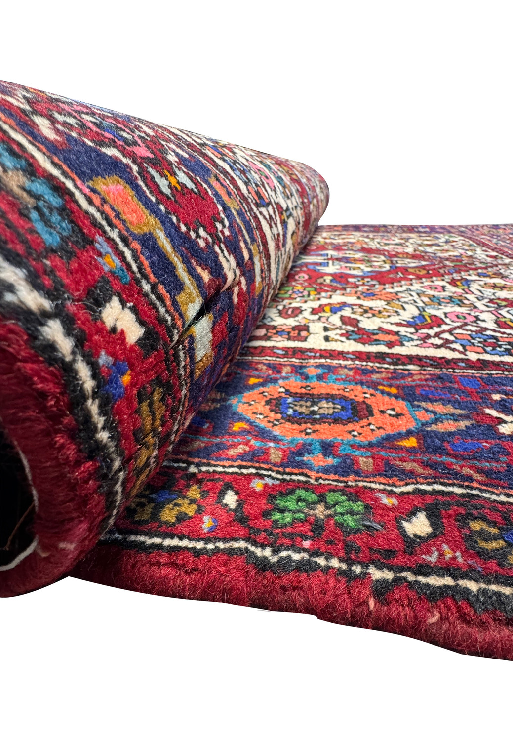 A section of the 3'3 x 5 Persian Bijar rug rolled up, revealing the density of the weave and the rug's plush pile.