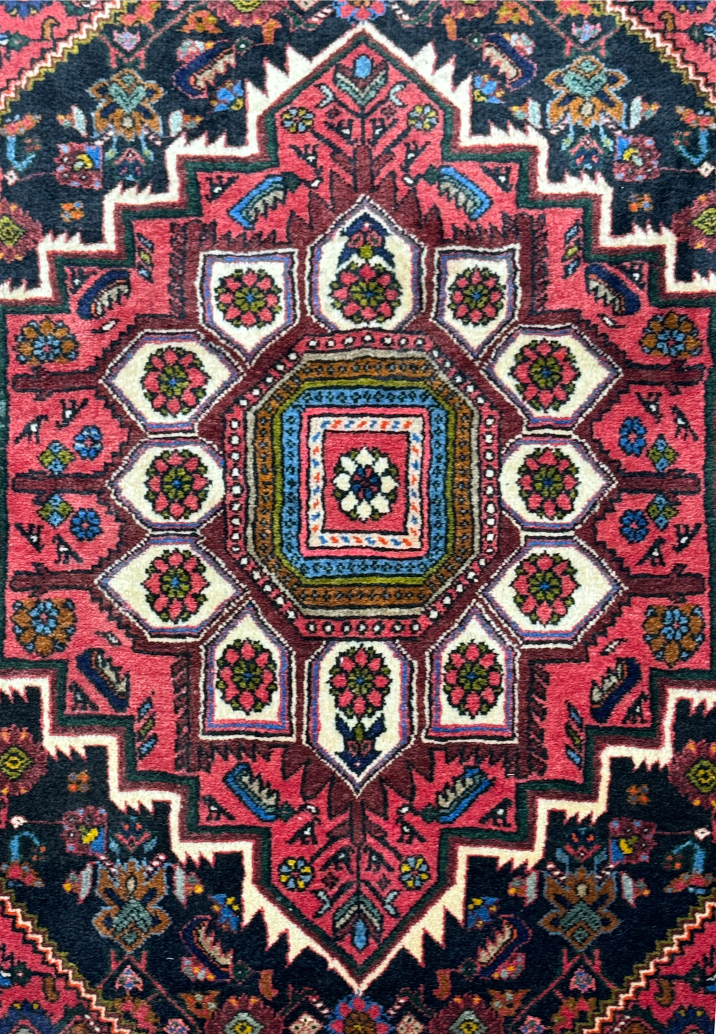 Close-up of the central medallion of a Persian Gholtogh rug, highlighting the detailed patterns and rich colors