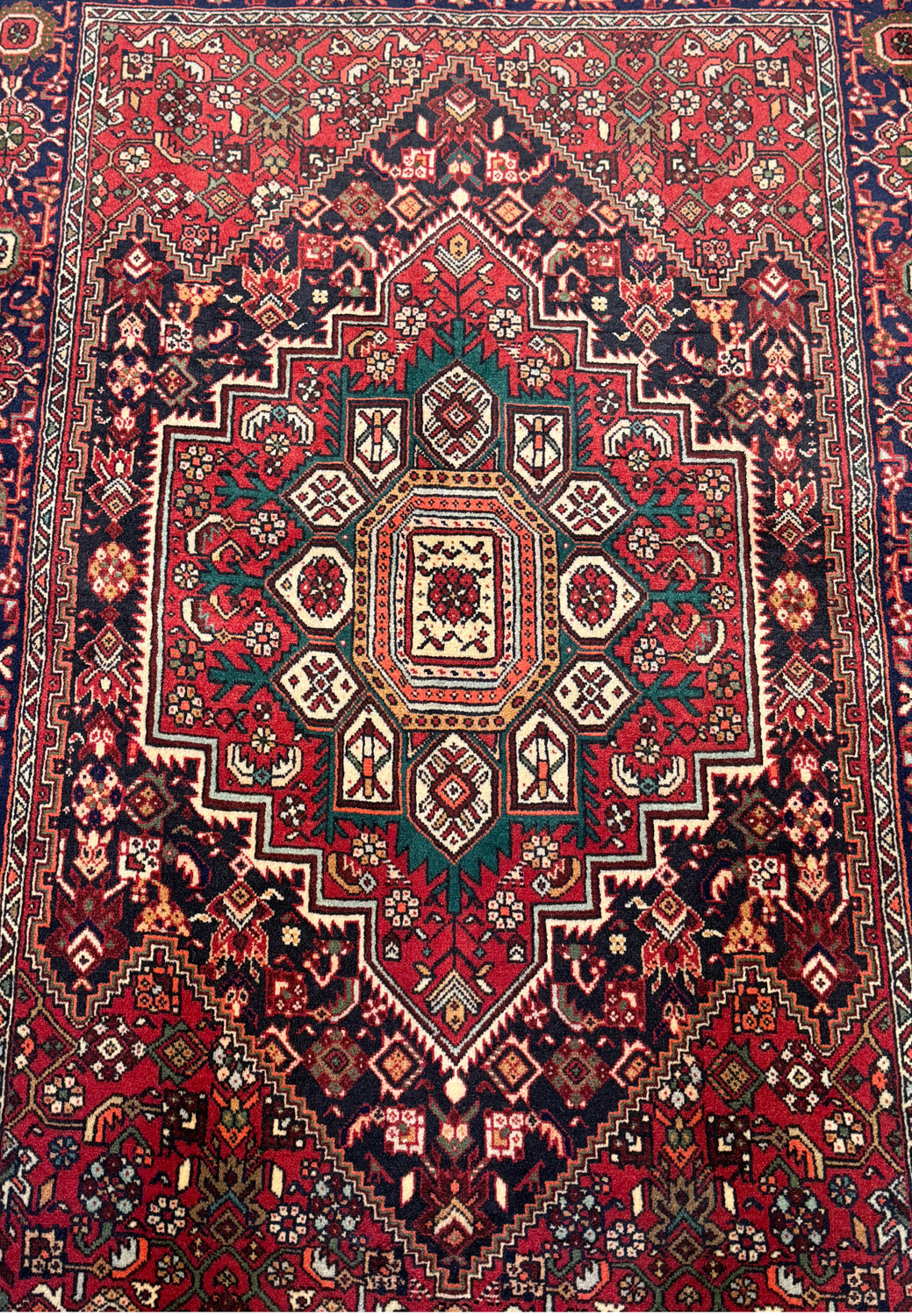 Close-up of the central medallion of a Persian Gholtogh Rug, showcasing the intricate weaving and vibrant color details