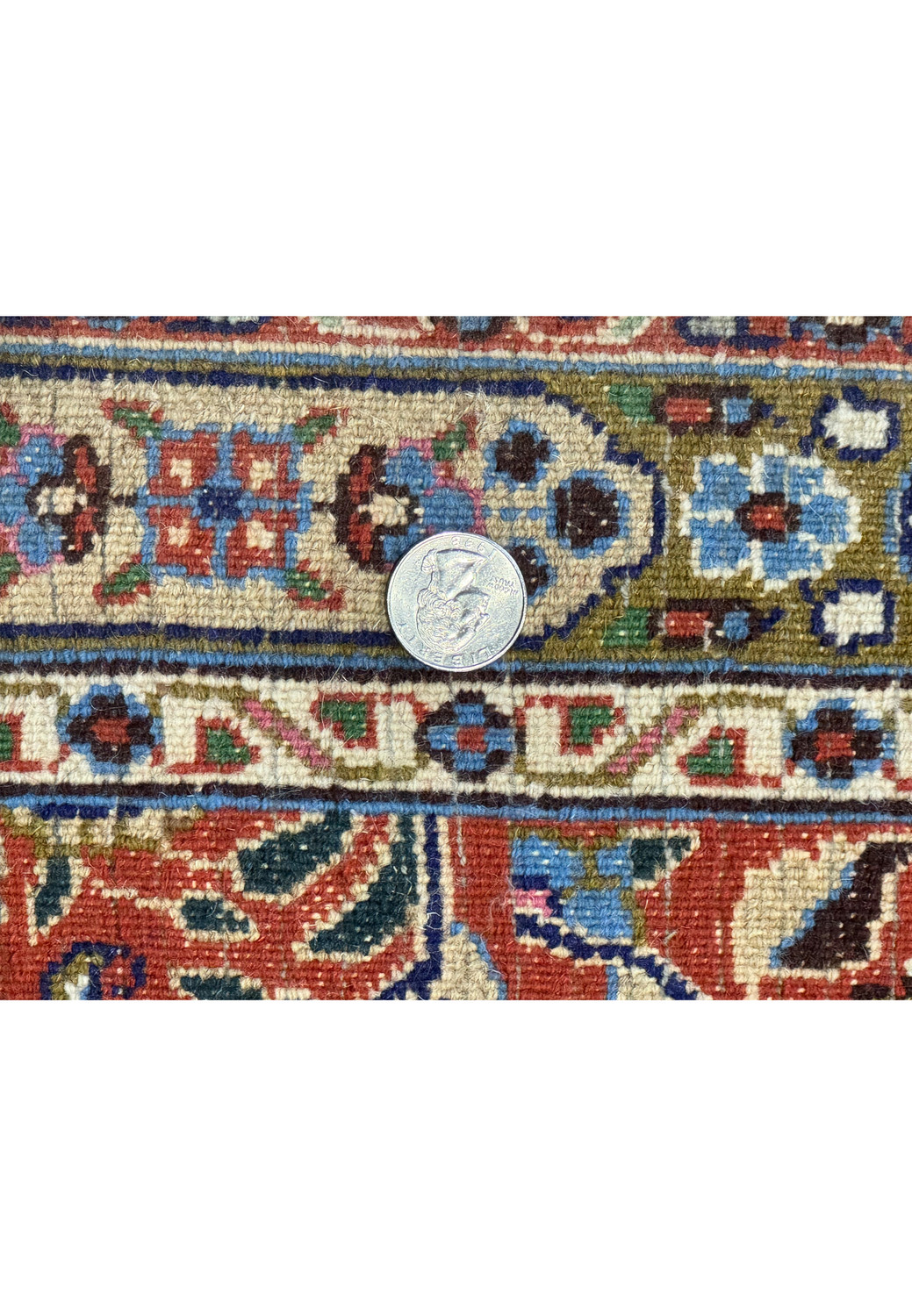 A close-up image showing a quarter coin placed on the Persian Moud Rug to demonstrate the high density of the weave and the fine quality of the craftsmanship