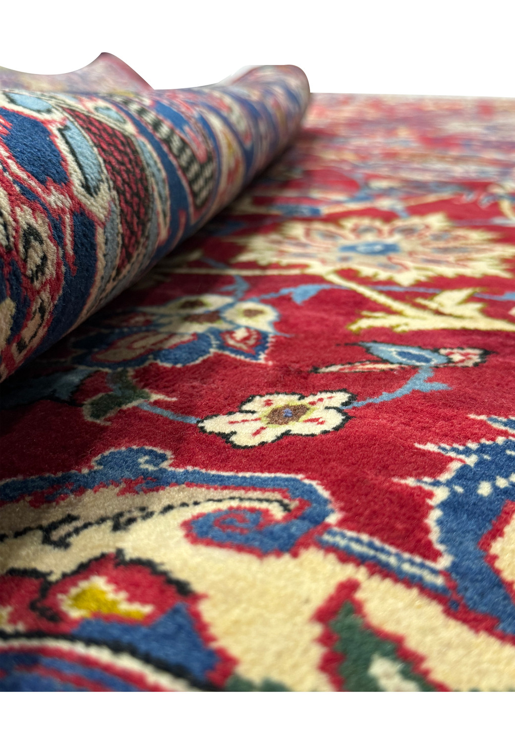 A full view of a 10 x 15'6" Persian Isfahan rug, with a detailed floral pattern spread across a crimson field and surrounded by a navy blue intricate border