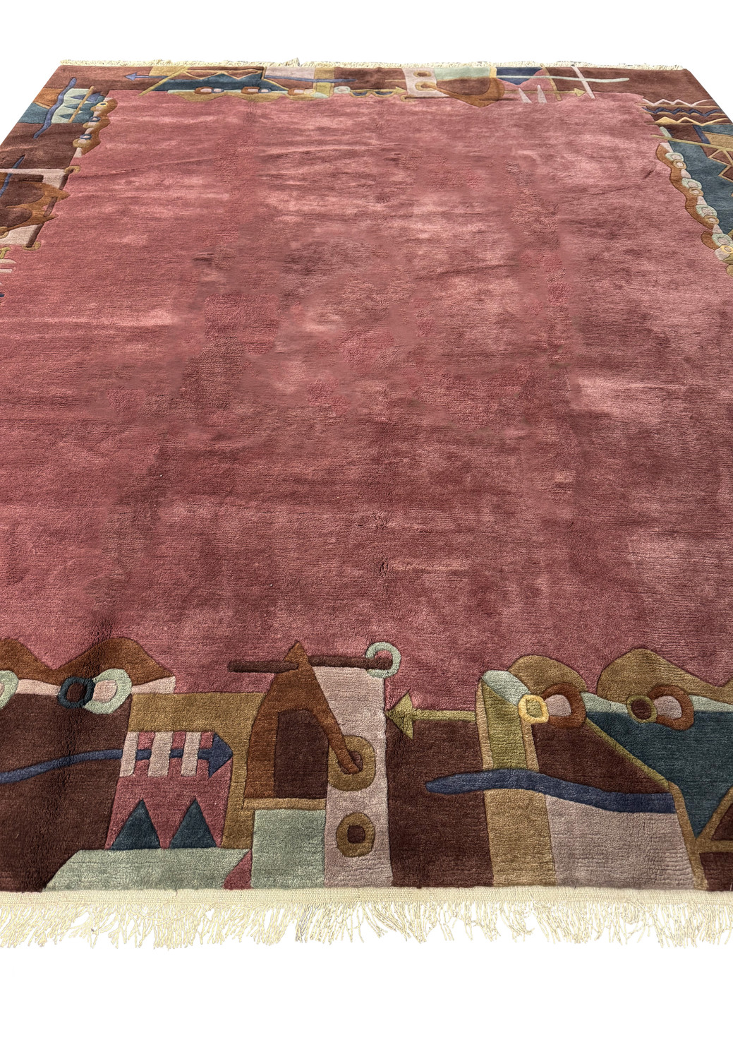 Close-up of modern dusty rose Tibetan rug showcasing plush texture and border detail