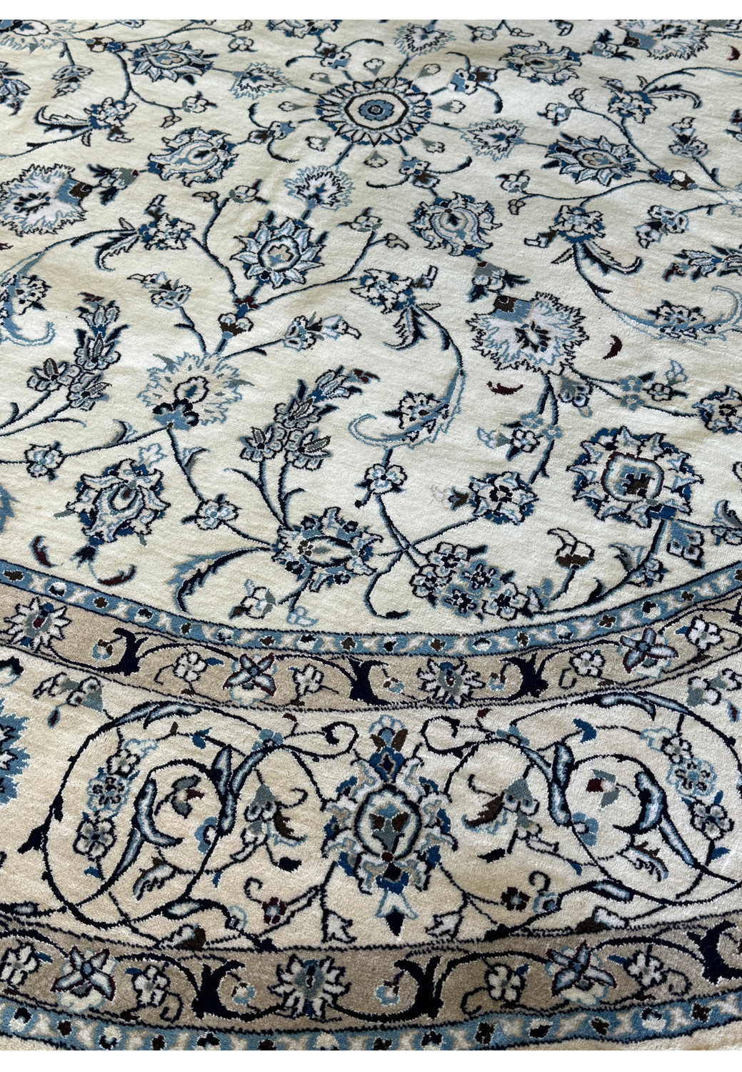 Ivory and blue Persian Nain round rug with traditional design.