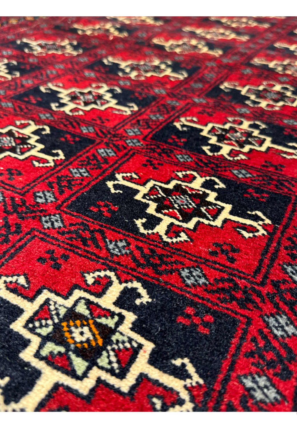 Close-up of the bottom section of the rug, showing the detailed border patterns and the fringed edge.