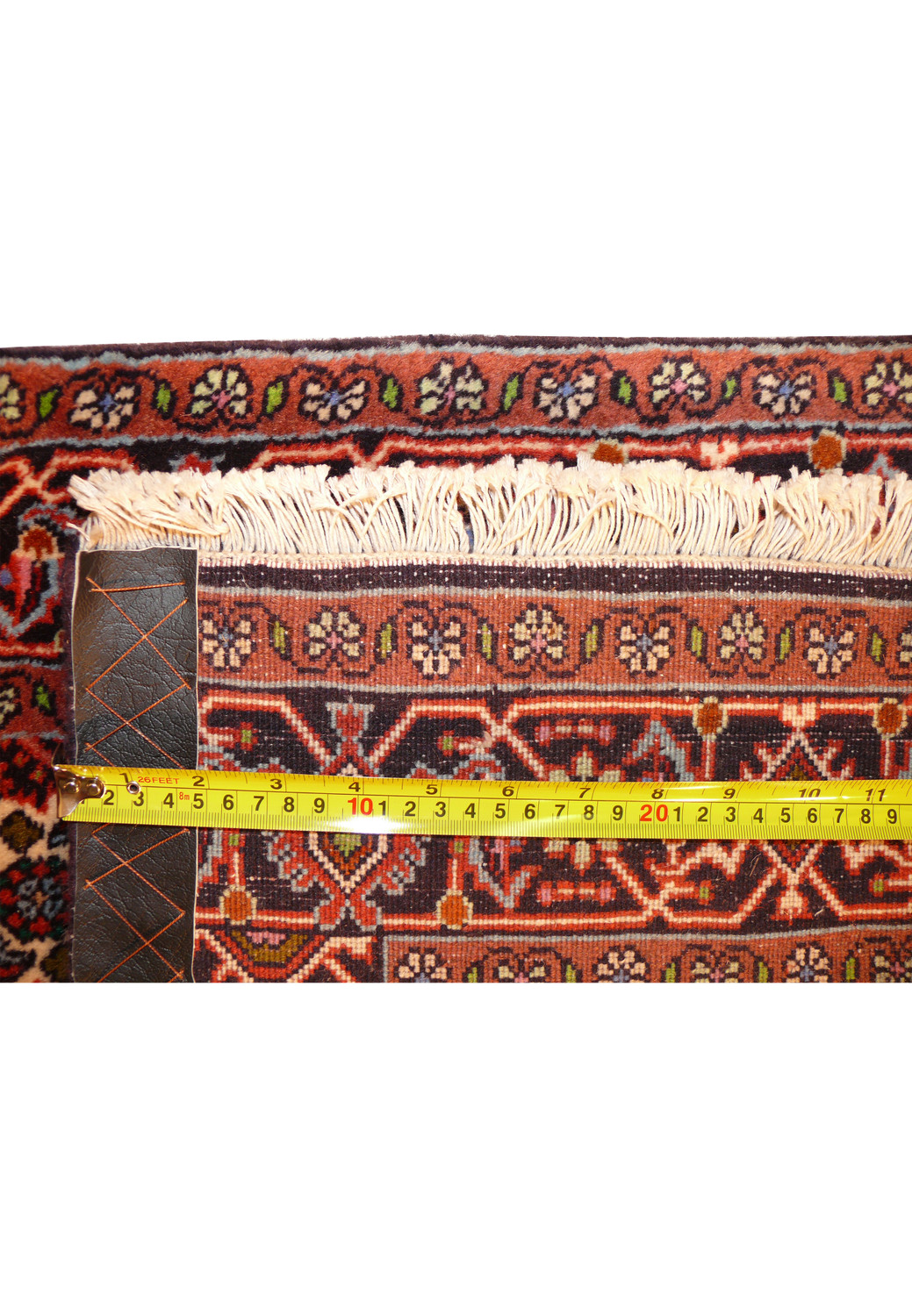 Tape measure on the short edge of the 3x10 Persian Bijar Runner Rug, demonstrating the precise knot density and the rug's dense weave.