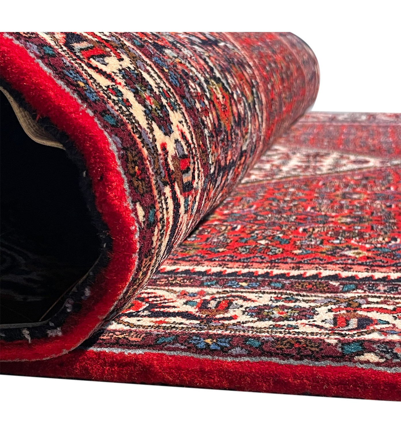 Rolled Persian Bijar rug, with a glimpse of the pattern, highlighting the thickness and quality of the rug.
