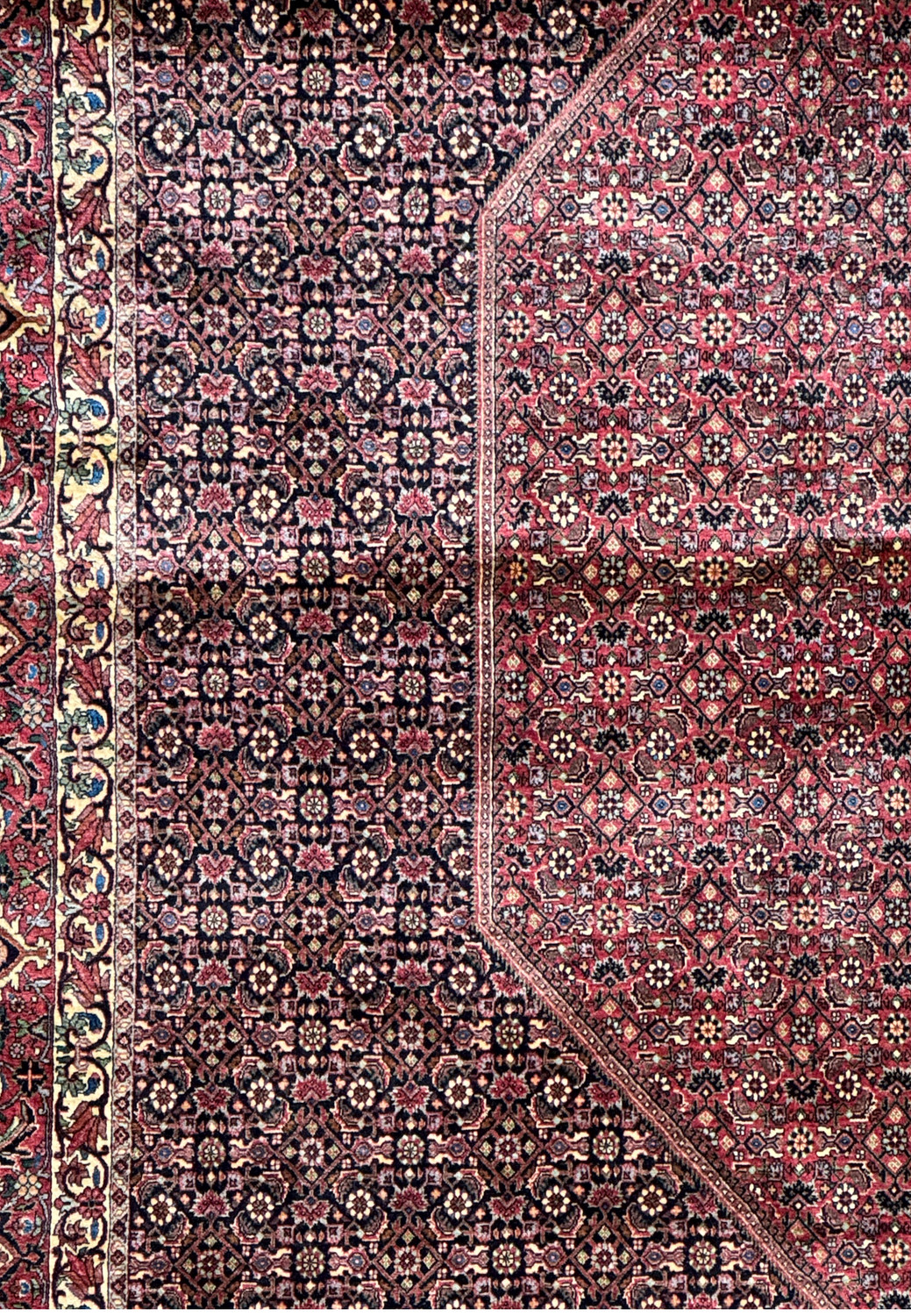 Detailed perspective of the Persian Bijar rug's corner, showing the exquisite border design with floral motifs in contrasting colors