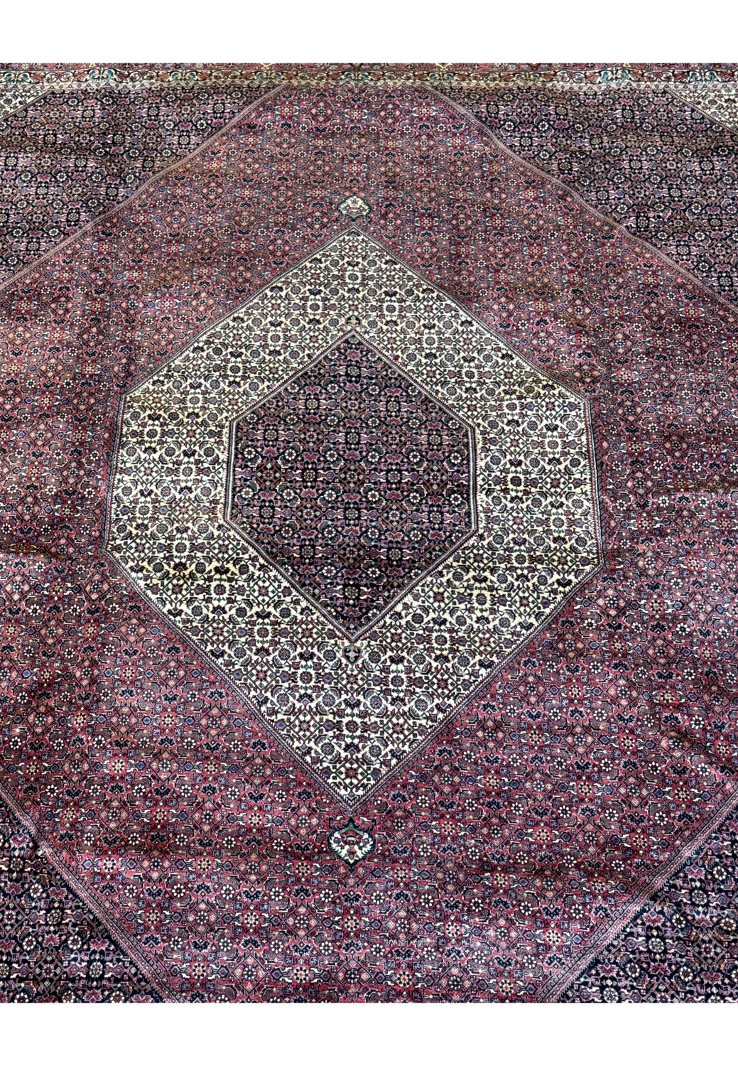 A focused view on the dense and intricate patterns that make up the central diamond medallion of the Persian Bijar rug