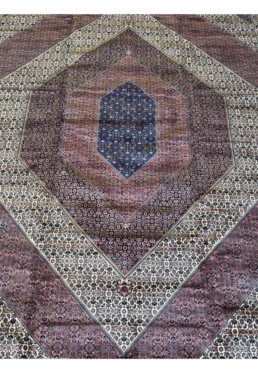 Perspective shot of a Persian Bijar rug, highlighting the textural details and the interplay of weave patterns.