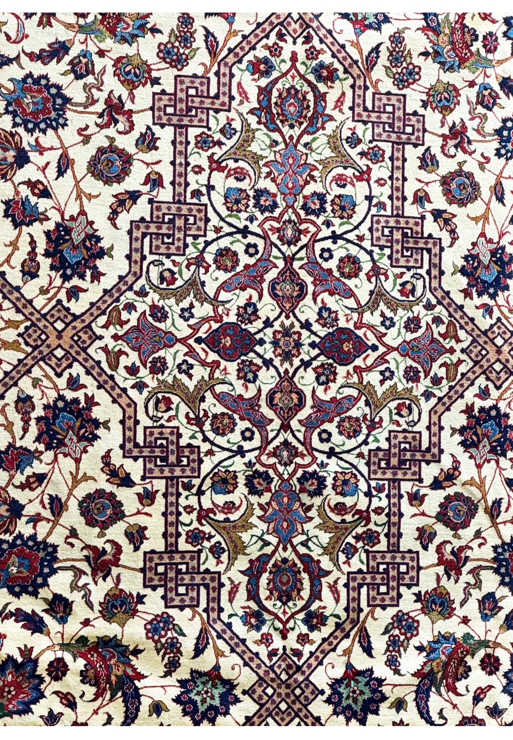 Close-up of the Persian Isfahan rug showing a central medallion with intricate designs in red, blue, and beige tones.