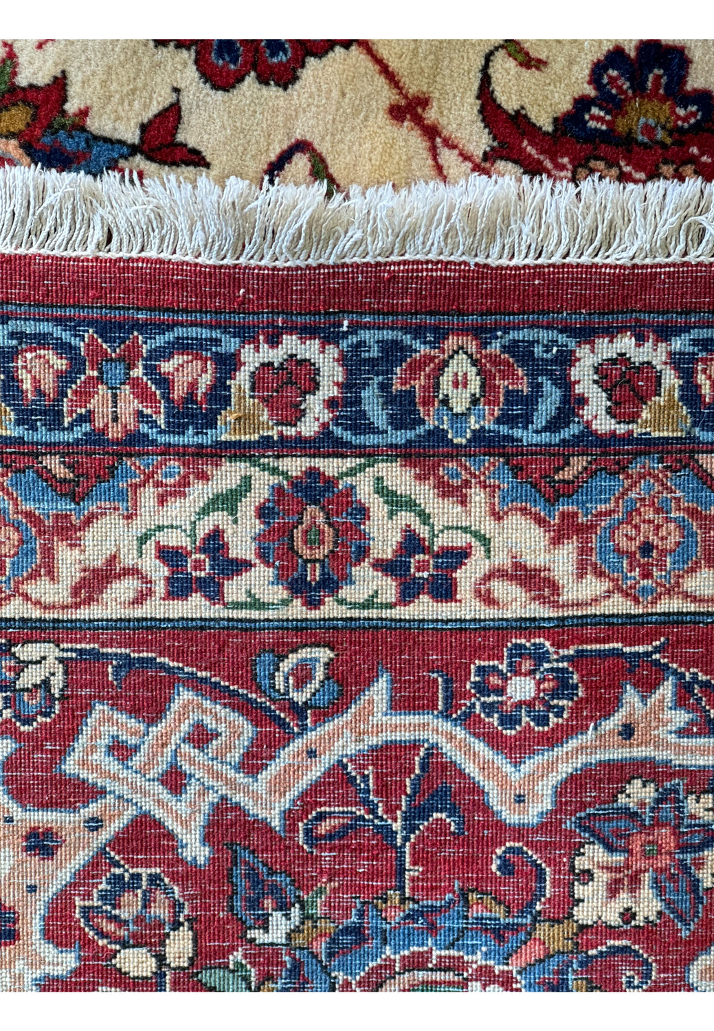 Edge view of a 10'7 x 14'7 Persian Isfahan Wool & Silk Rug, illustrating the border patterns and the rug's fringe.