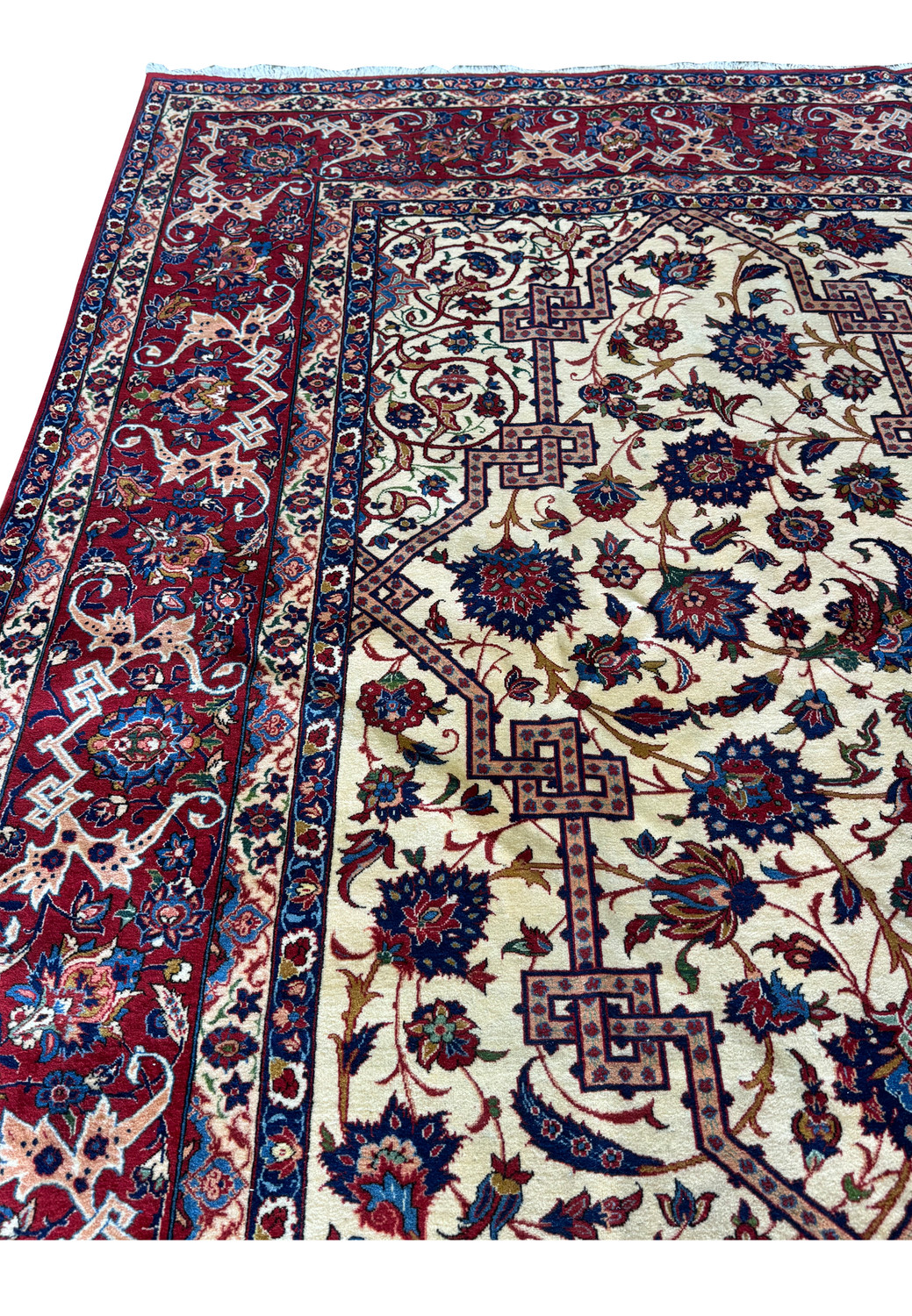 Angled view of a 10'7 x 14'7 Persian Isfahan Wool & Silk Rug, displaying the intricate floral and geometric patterns along the border and central area